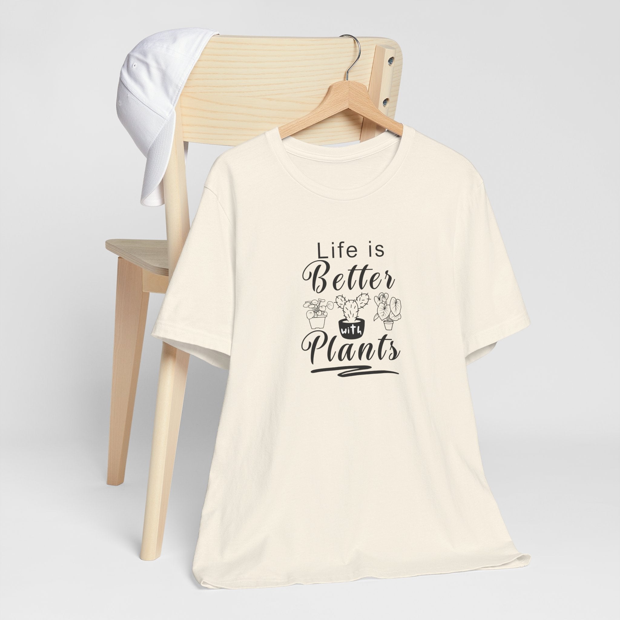 A hanging tee shirt with the text "Life is Better with Plants" printed on the front. The shirt comes in a natural color.