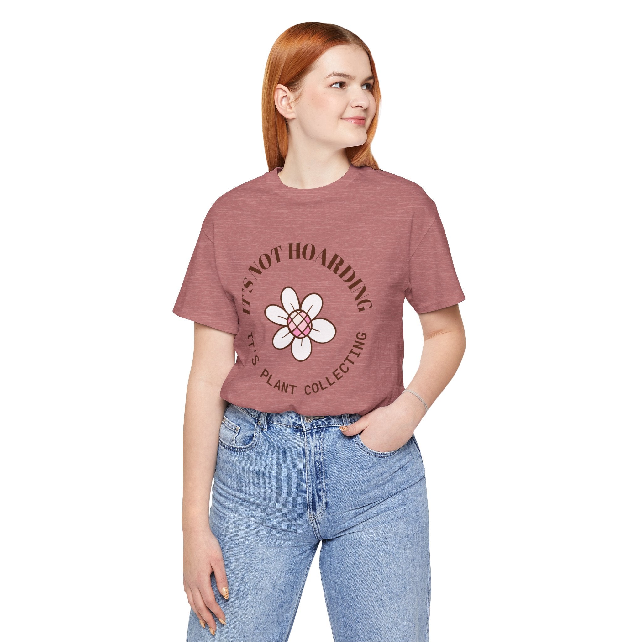 A heather mauve colored shirt with text that says "It's not hoarding" "It's plant collecting."  The shirt design also has a groovy flower. The shirt is an excellent gift for teen and adult female houseplant collectors. Perfect for birthdays and Christmas gifts.