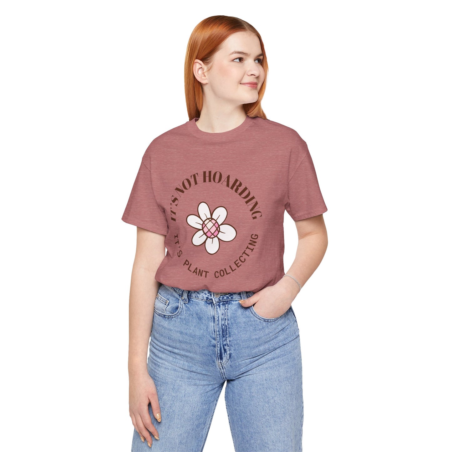A heather mauve colored shirt with text that says "It's not hoarding" "It's plant collecting." The shirt design also has a groovy flower. The shirt is an excellent gift for teen and adult female houseplant collectors. Perfect for birthdays and Christmas gifts.