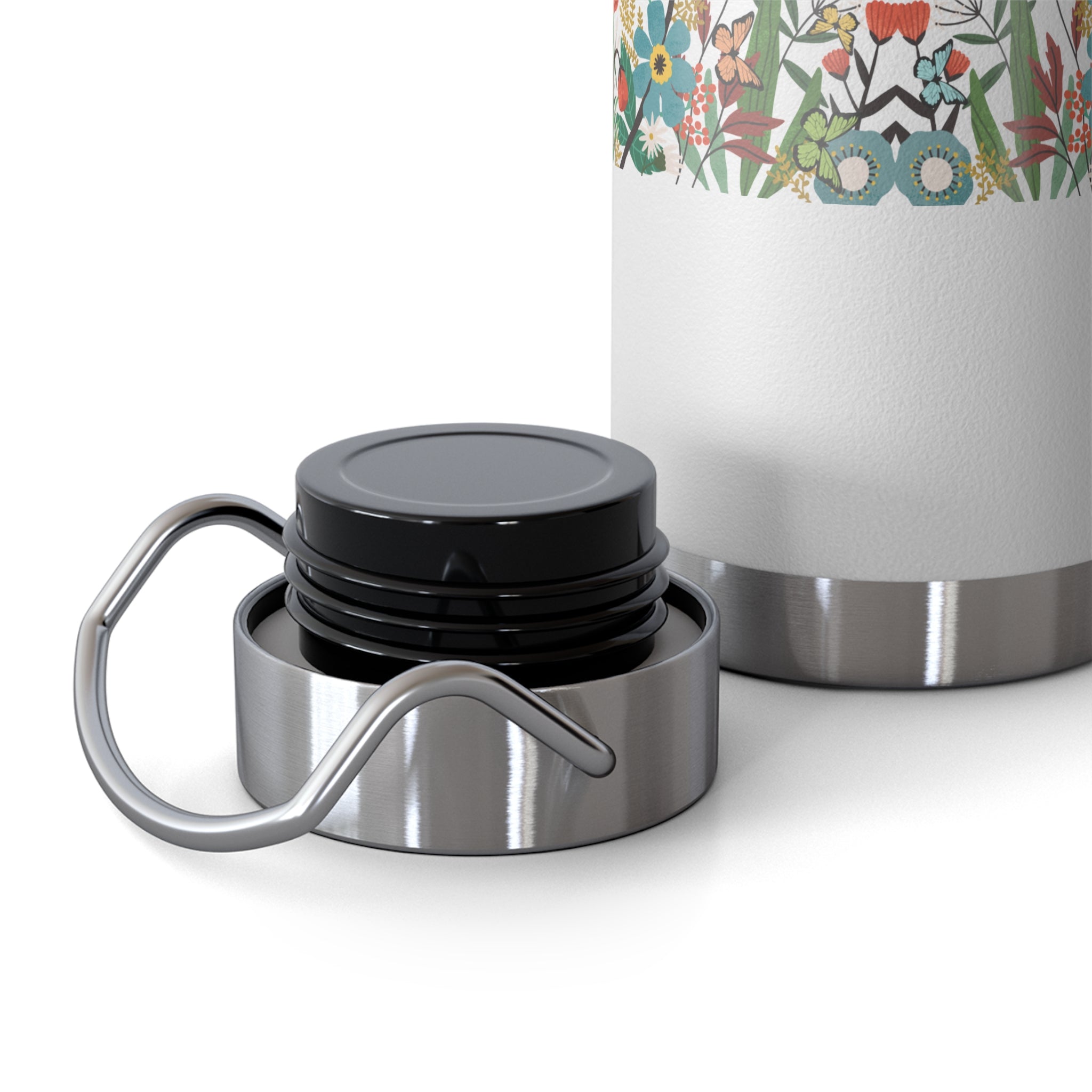 Silver insulated mug with black lid and floral-patterned sleeve on a white background