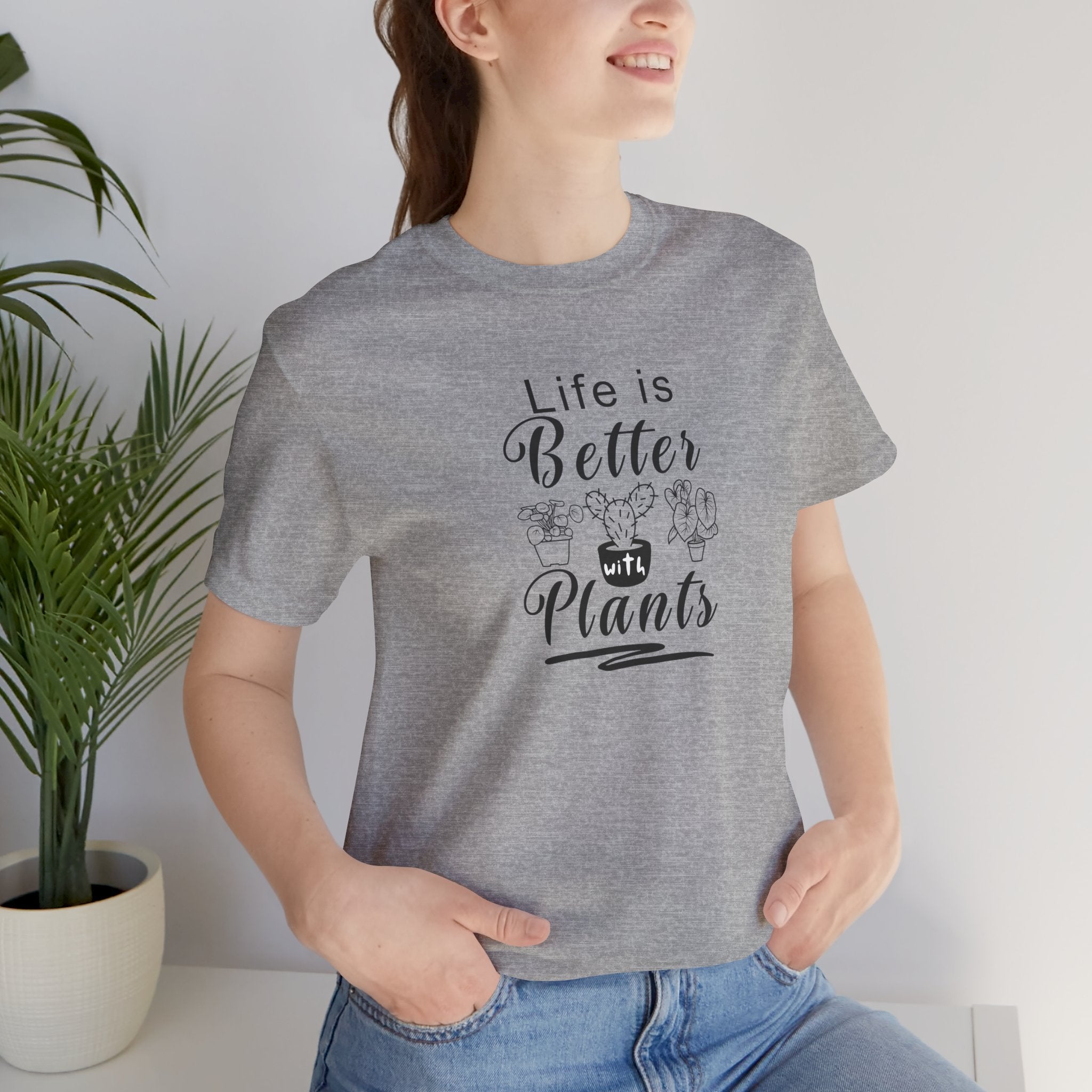 a person wearing a gray shirt with "Life is Better with Plants" text in black