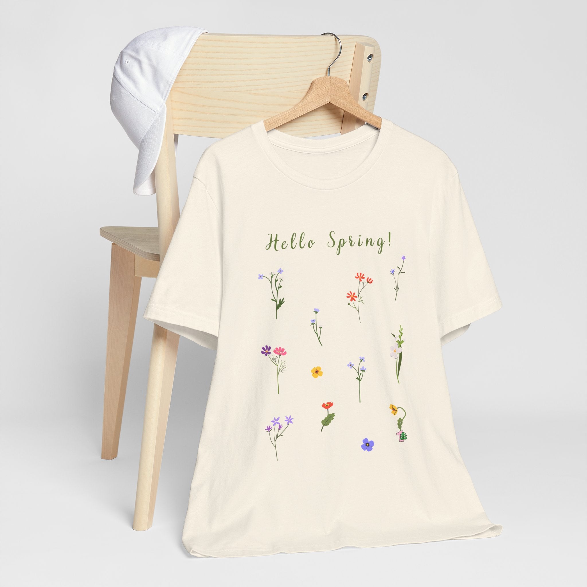 A shirt with wild flowers and text that says "Hello Spring!"