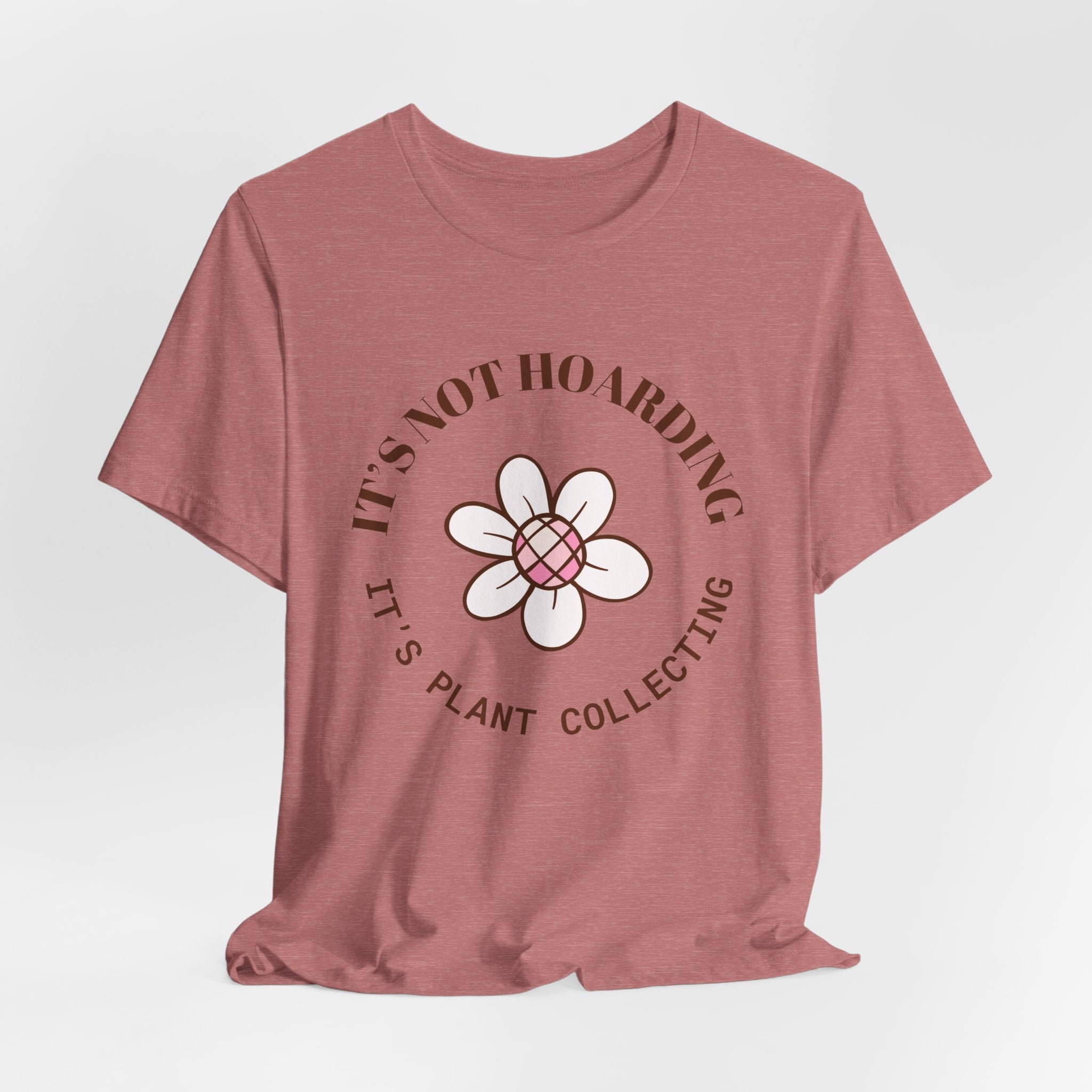 A heather mauve colored shirt with text that says "It's not hoarding" "It's plant collecting."  The shirt design also has a groovy flower. The shirt is an excellent gift for teen and adult female houseplant collectors. Perfect for birthdays and Christmas gifts.