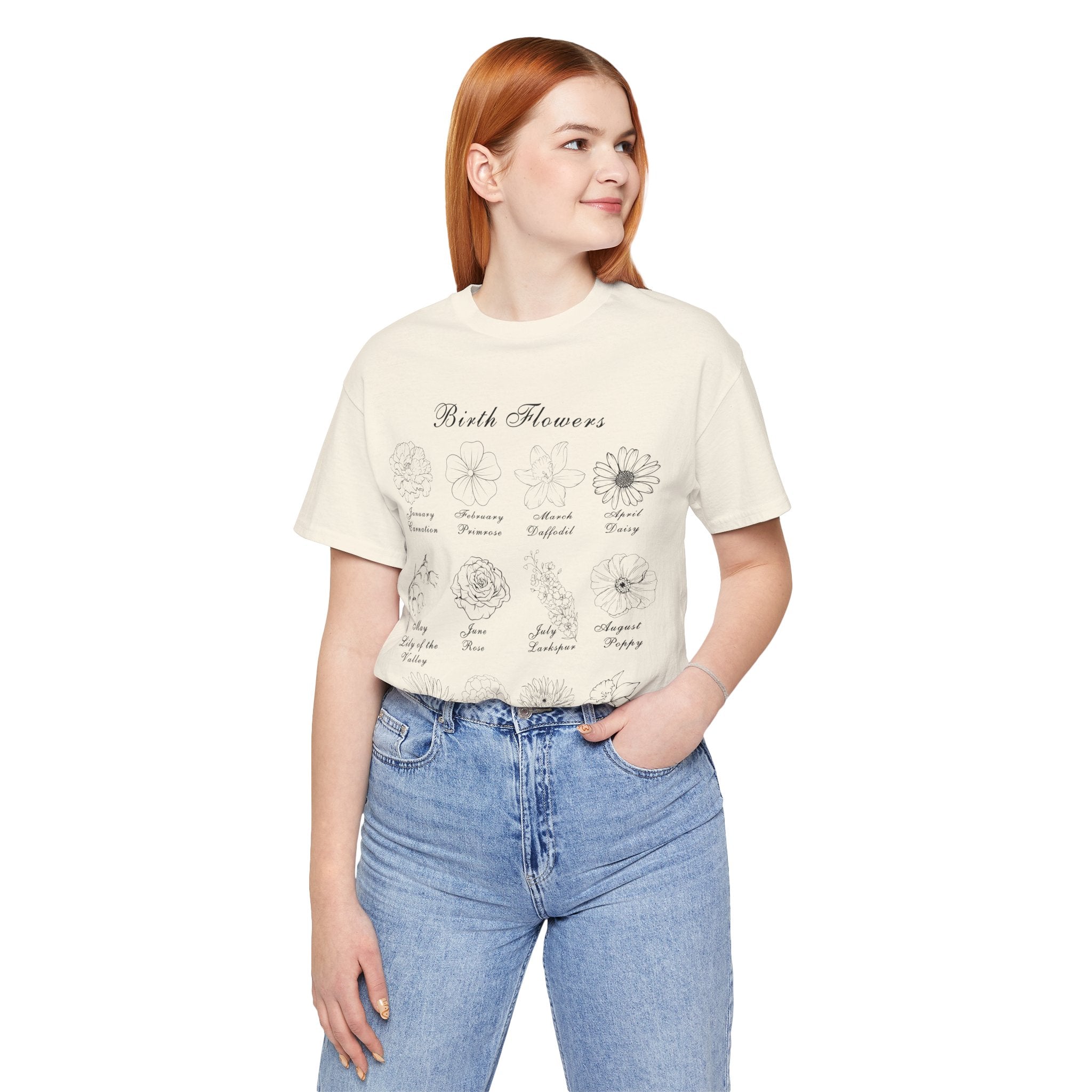 A woman wearing a shirt in a natural colored tone and a printed design of birth flowers.  Each month of the year is printed with a corresponding flower for that particular month.  The t-shirt has a crew neck and short sleeves.  It is also lightweight so it's perfect for layering.  It also makes an excellent birthday, Mother's Day, Valentine's Day or Christmas gift.