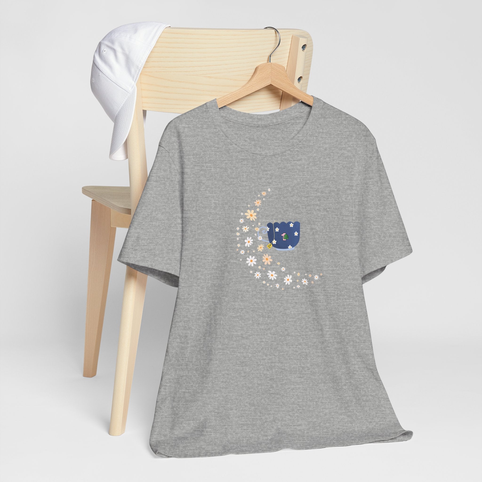 A tee-shirt featuring a floral moon and a teacup design.  It has a crew neck and short sleeves.