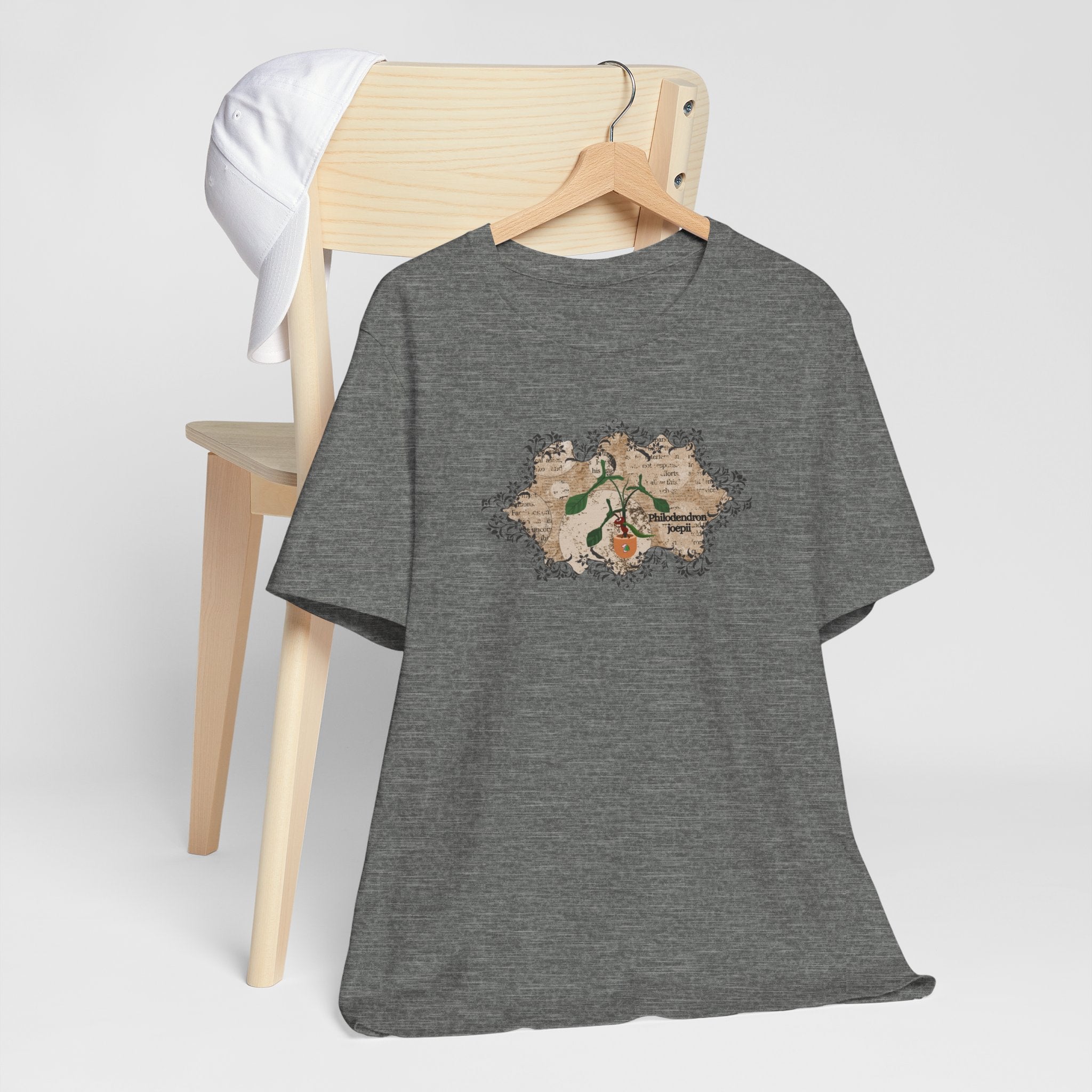 A soft plant t-shirt with a philodendron plant design. The philodendron joepii is printed on the t-shirt along with an ant eating the plant leaves. An excellent birthday gift for plant lovers.