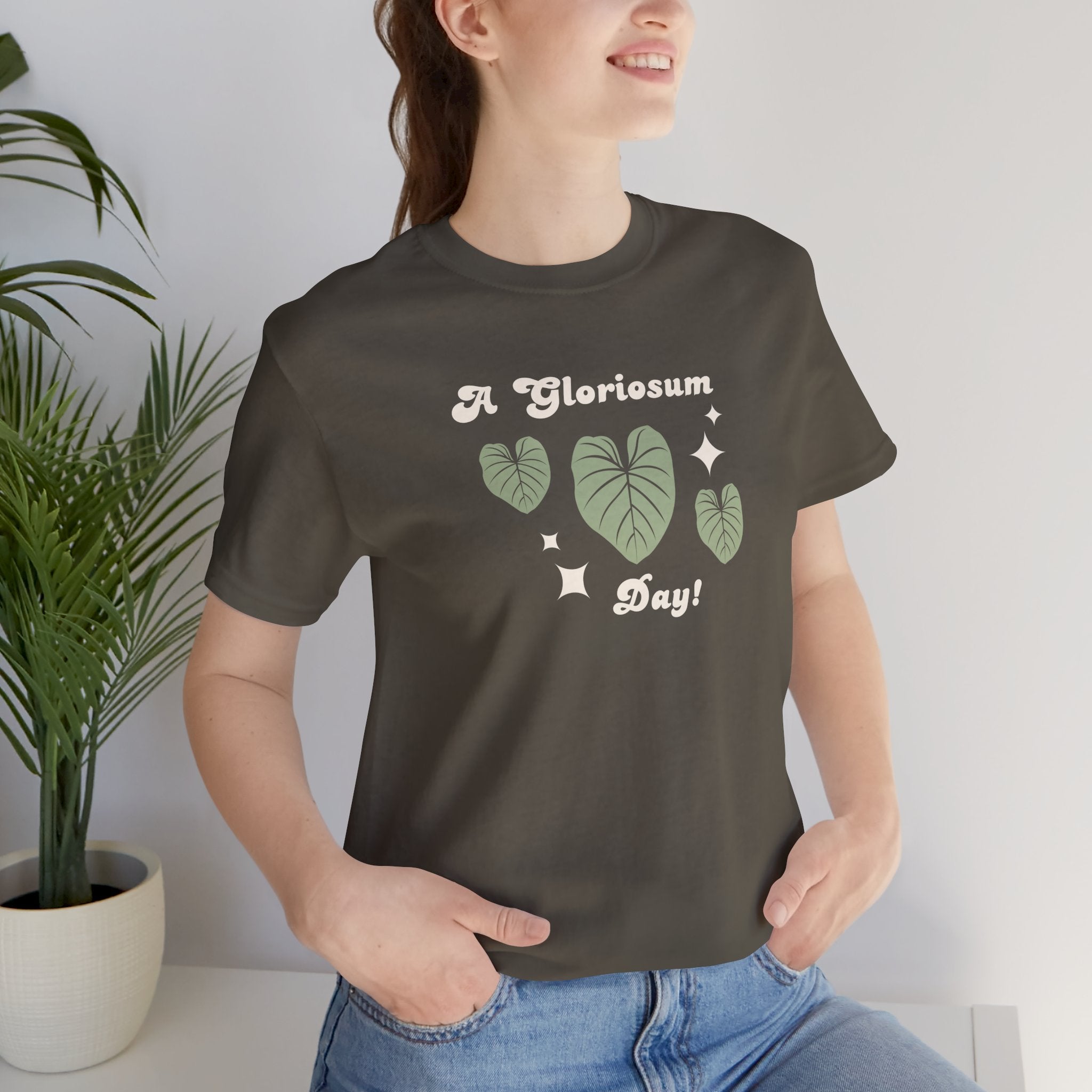 a woman wearing a "philodendron gloriosum day!" plant t-shirt