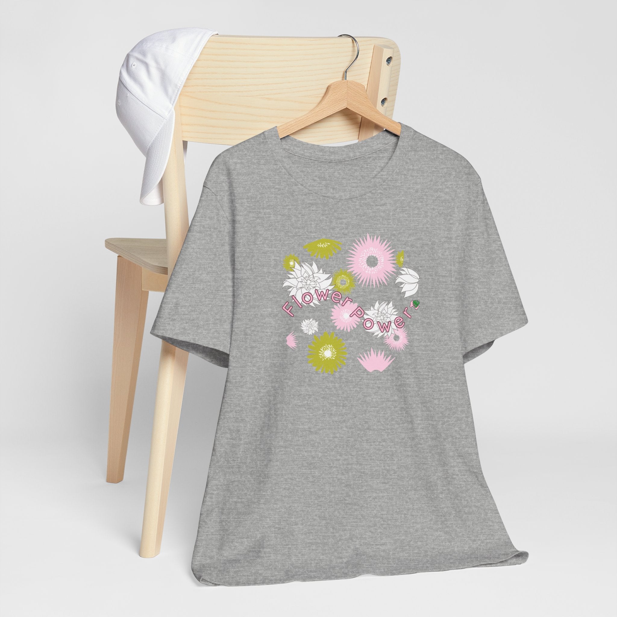 An athletic heather color tee shirt with the words flower power in pink.  There are also pink, white, and green flowers printed on the shirt.