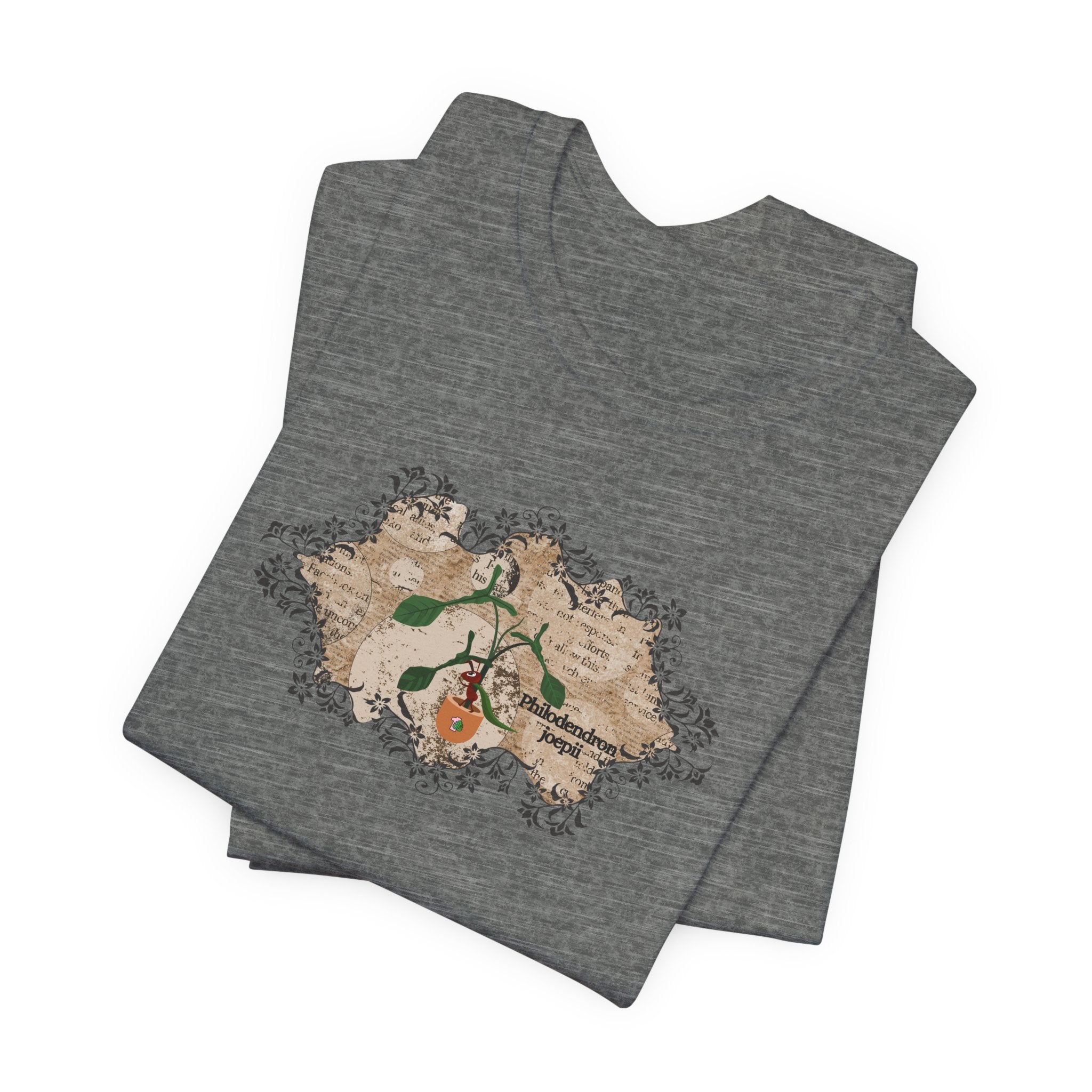 A folded plant t-shirt with a philodendron plant design. The philodendron joepii is printed on the t-shirt along with an ant eating the plant leaves.