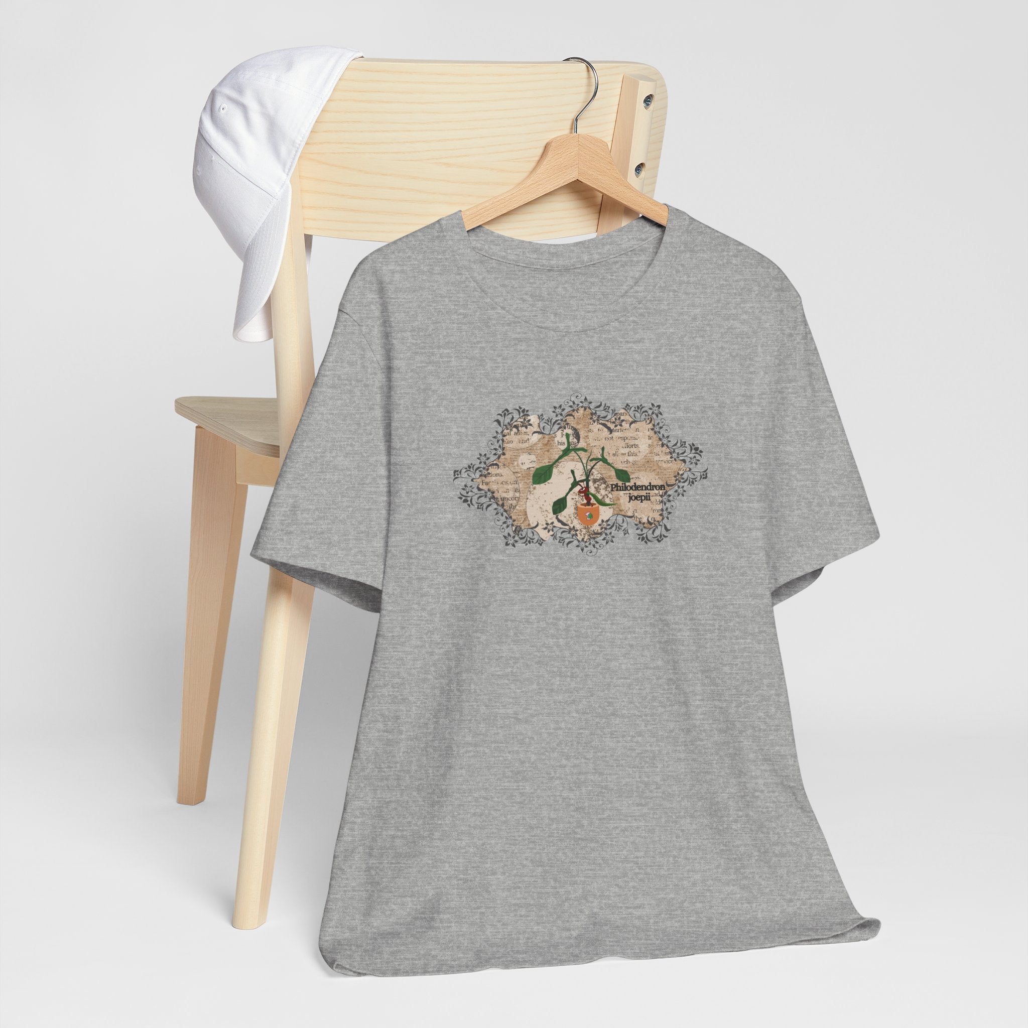A tee shirt with a philodendron joepii plant design, an ant eating the plant, and the 1pink1 plants logo. Perfect plant t-shirt for plant lovers