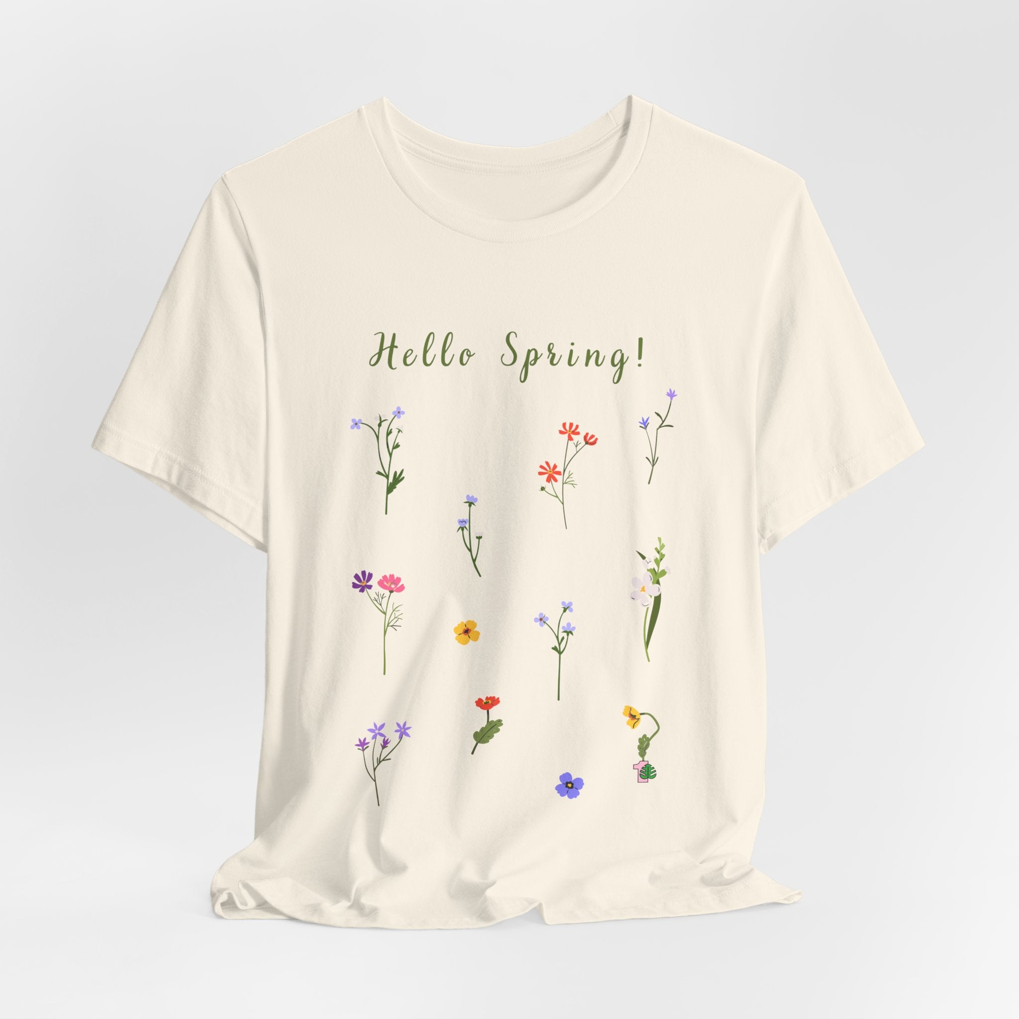 A casual t-shirt with wild flowers and text that says "Hello Spring!"