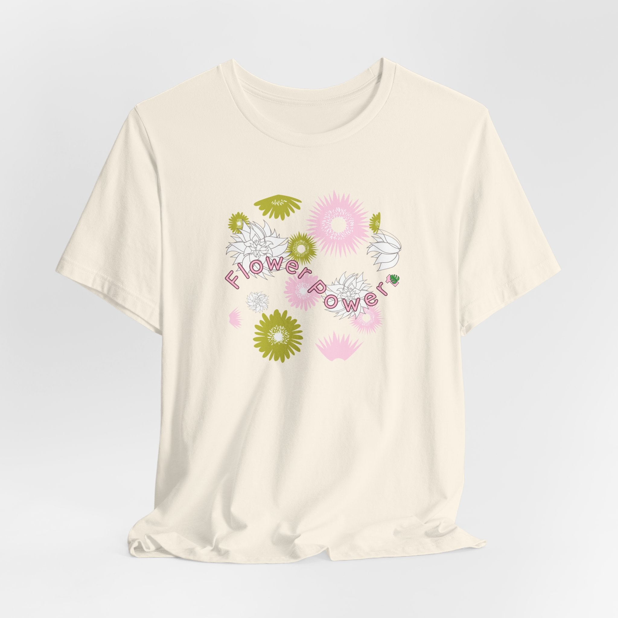 A natural color tee shirt with the words flower power in pink.  There are also pink, white, and green flowers printed on the shirt.