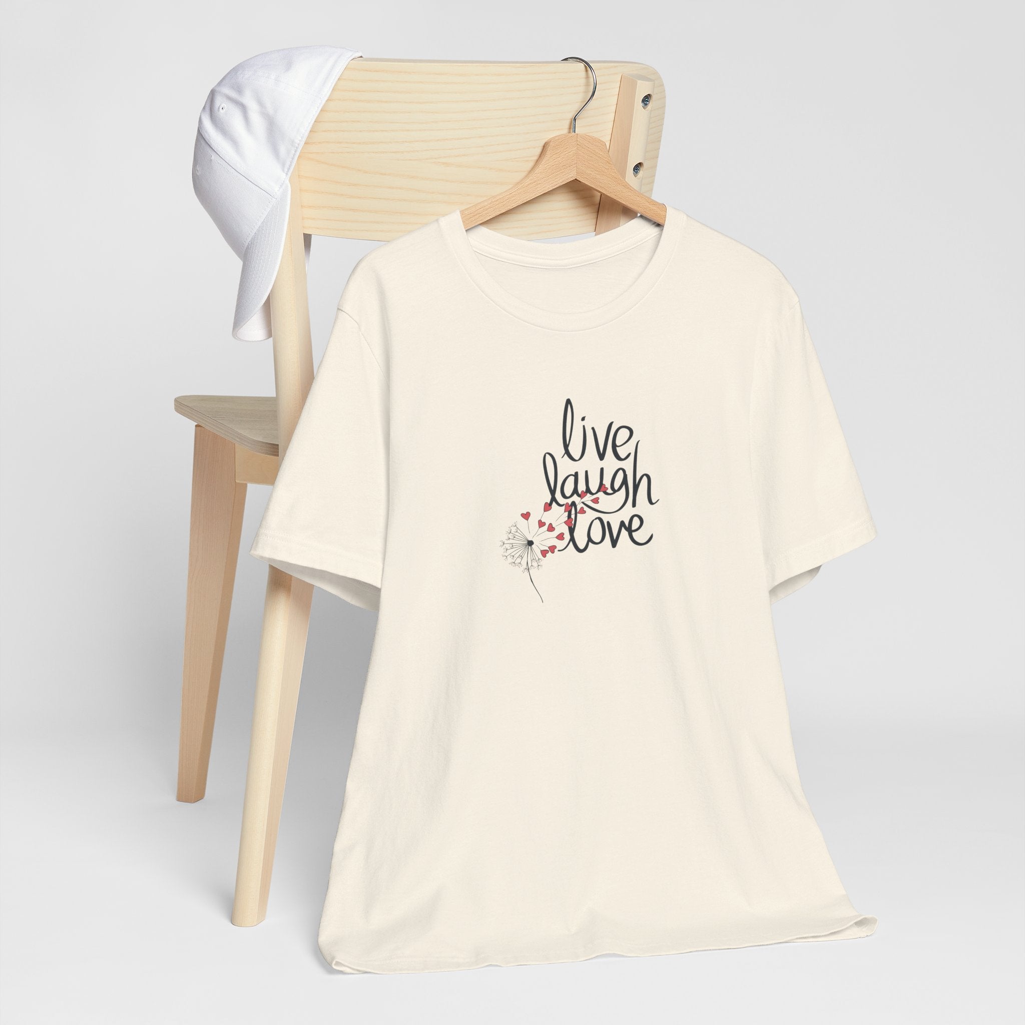 a graphic tee with text that says "live, laugh, love," and a dandelion with hearts.