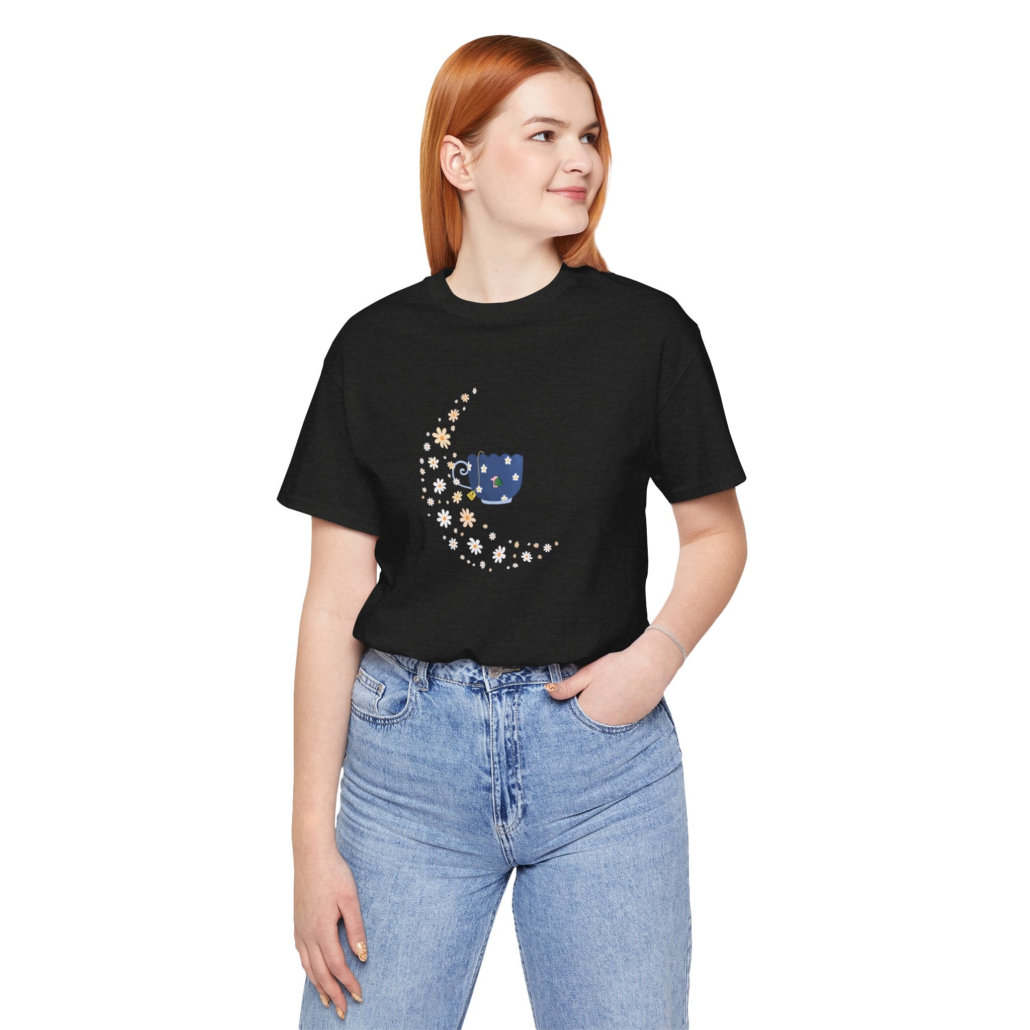 A young lady wearing whimsical floral moon and floral tea cup printed on a folded black colored shirt. The perfect light weight tee shirt for relaxing at home. 