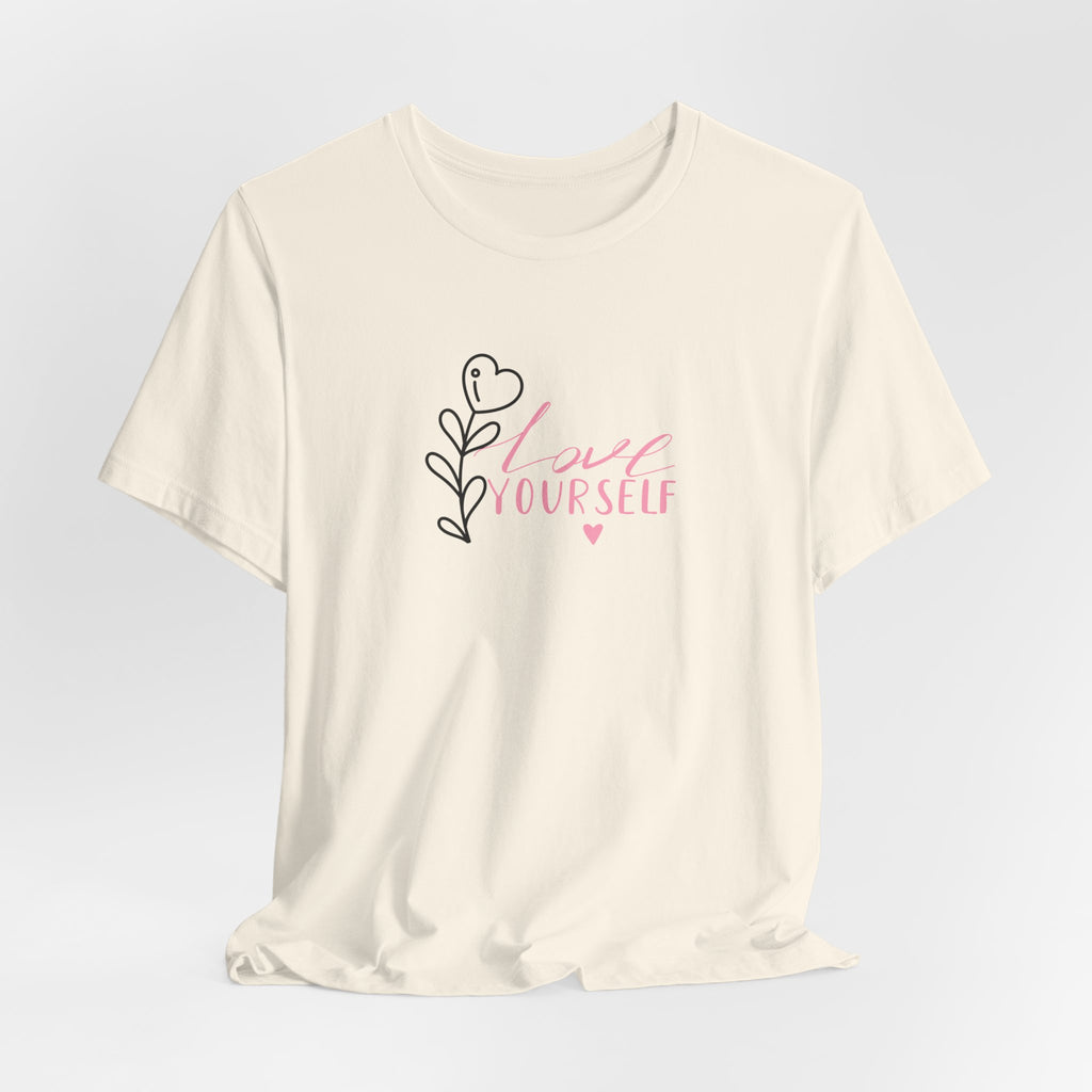 Picture of a natural color tee shirt with pink text that says "love yourself".  