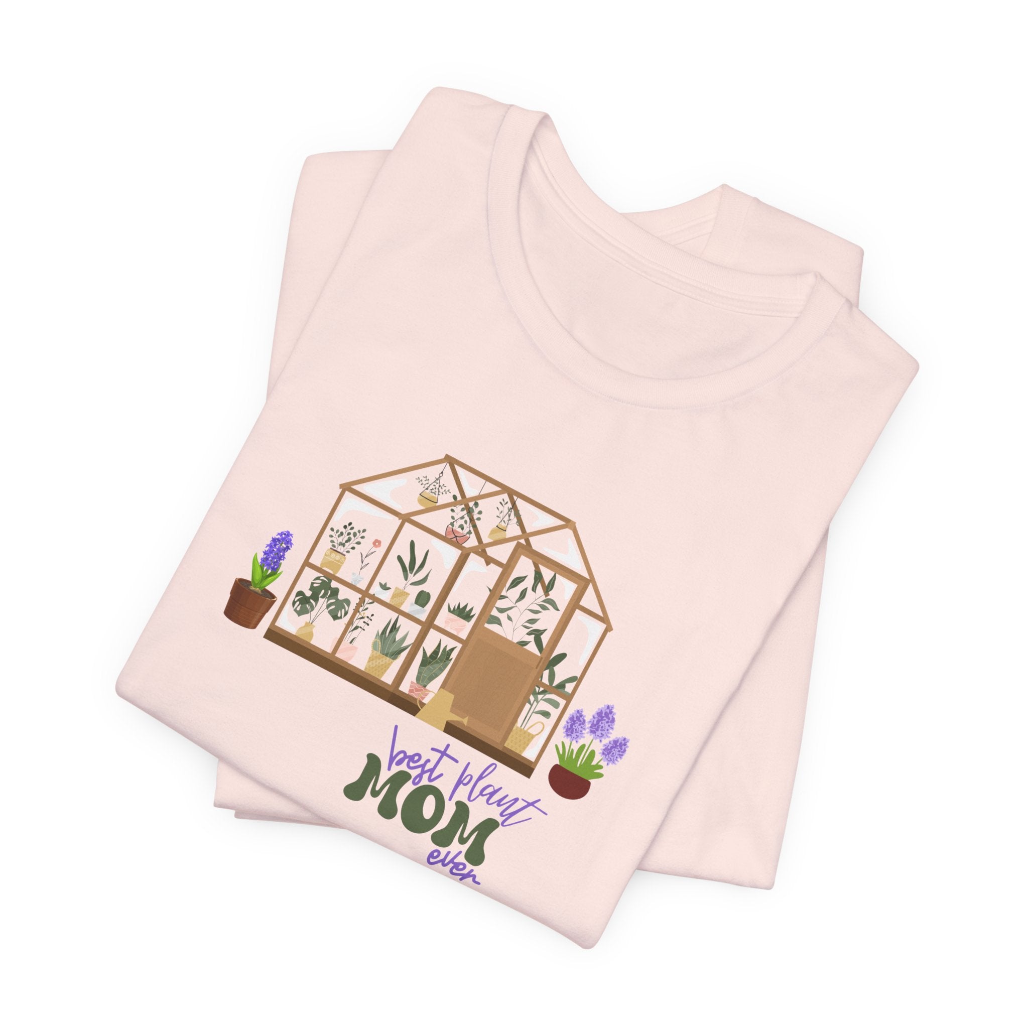 A jersey short sleeve tee in soft pink color and a greenhouse design.  There is also printed text that says best plant mom ever.