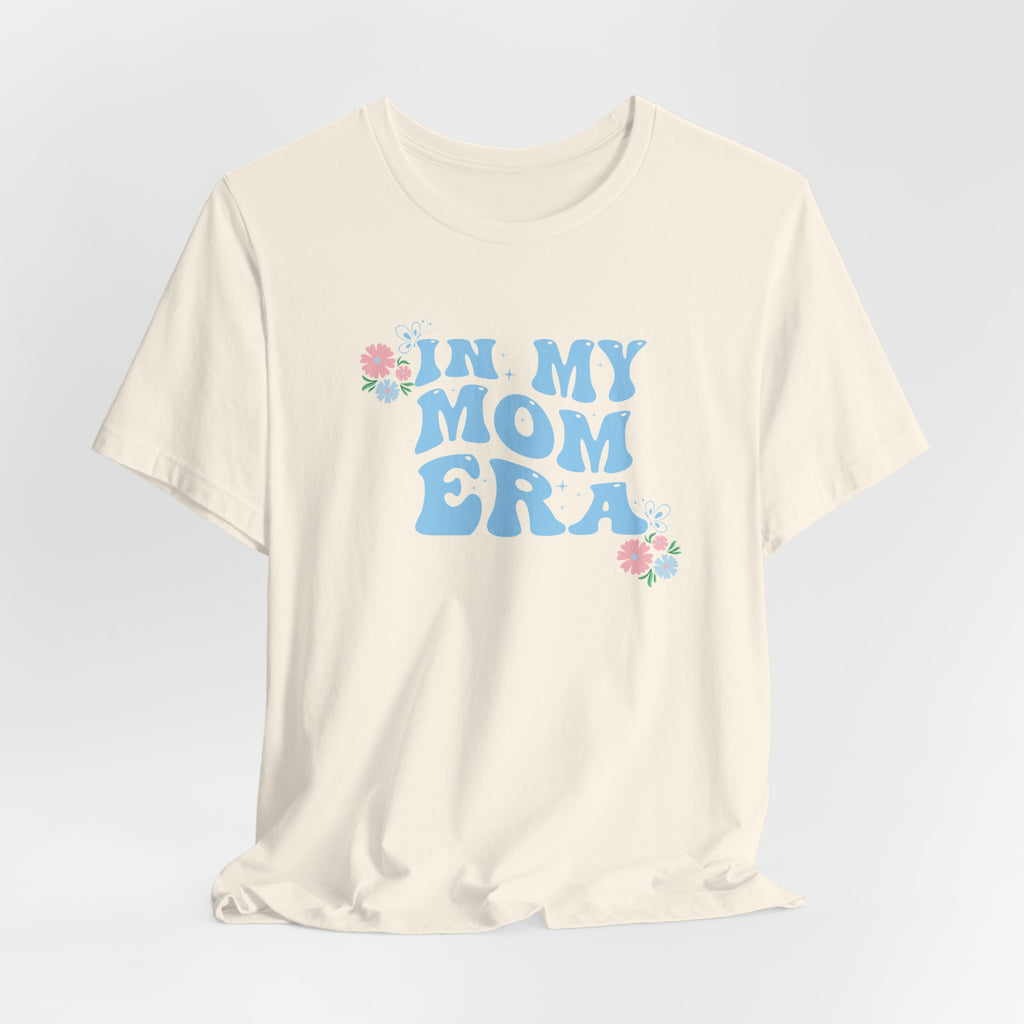 a natural color graphic tee with the words "In my mom era" printed in blue. 