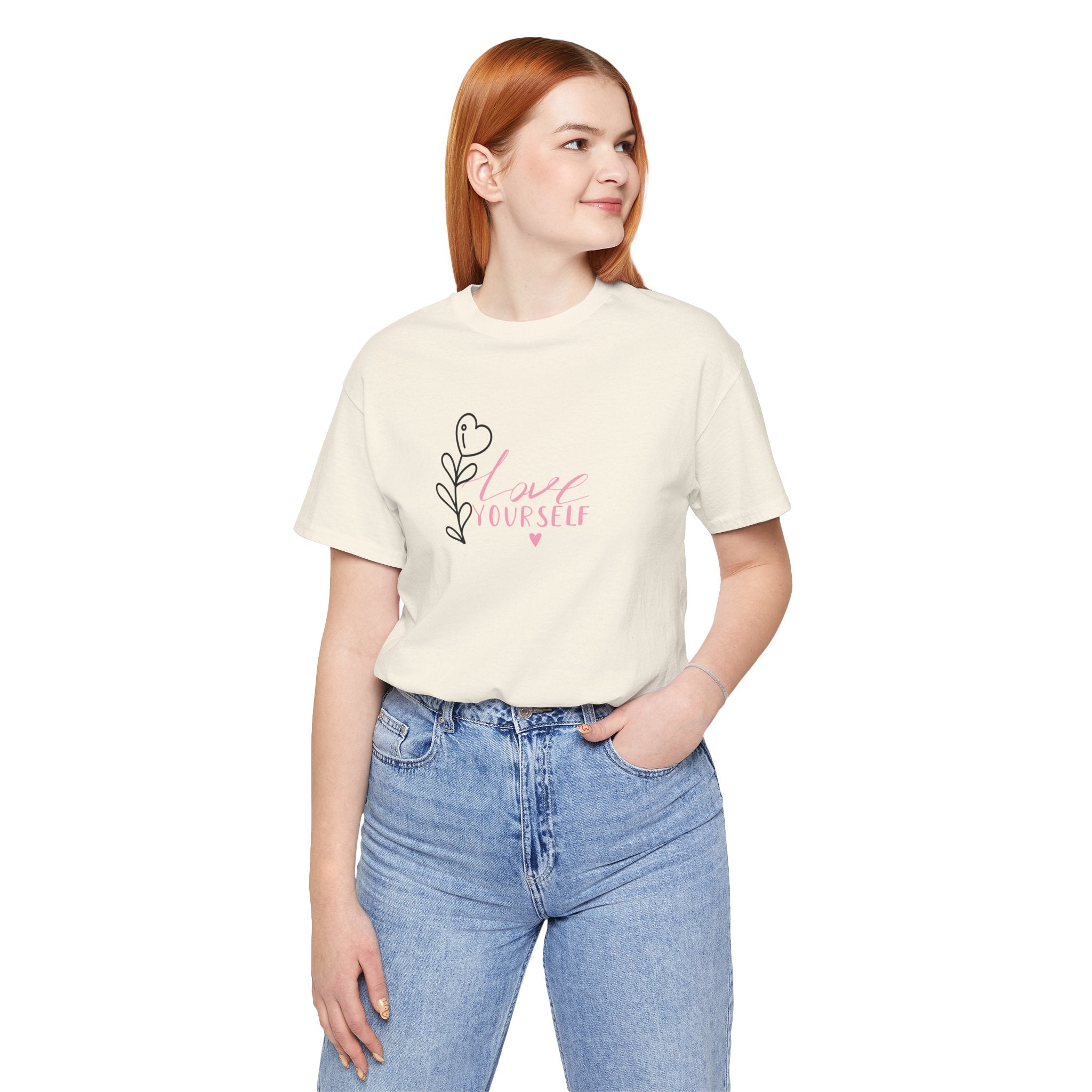 Picture of a person wearing a natural color shirt with pink text that says "love yourself".  