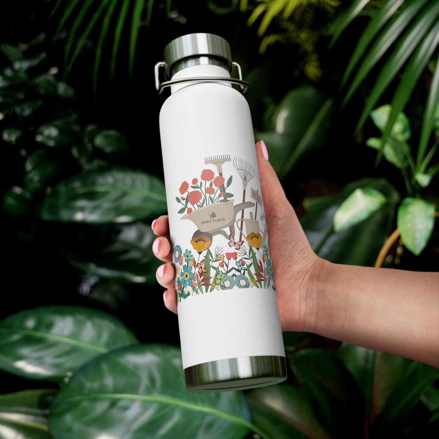 White water bottle with floral design held by a hand against a green leafy background