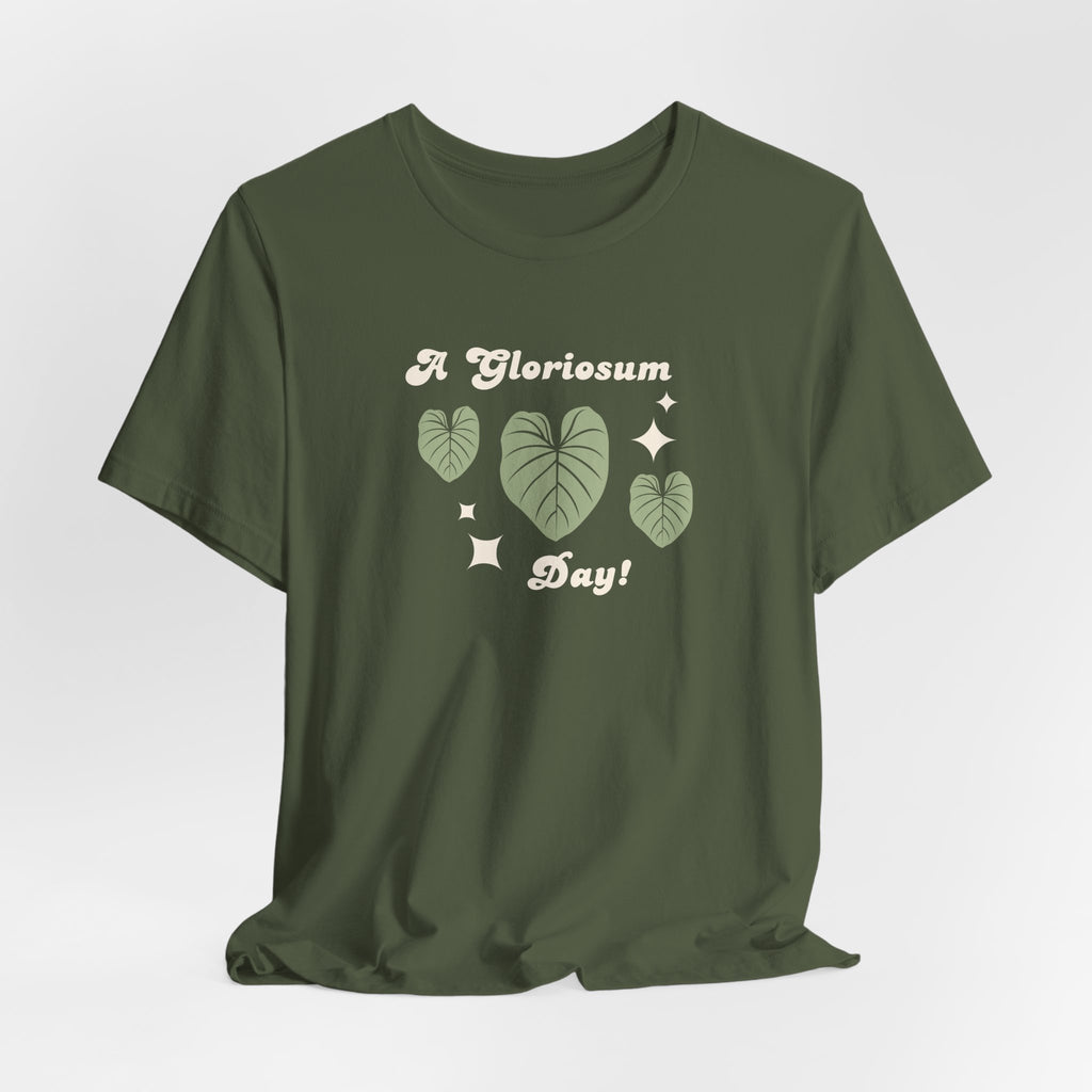 A military green tee shirt with text that says "A gloriosum day!"  The shirt design also has leaves from the philodendron gloriosum plant. 