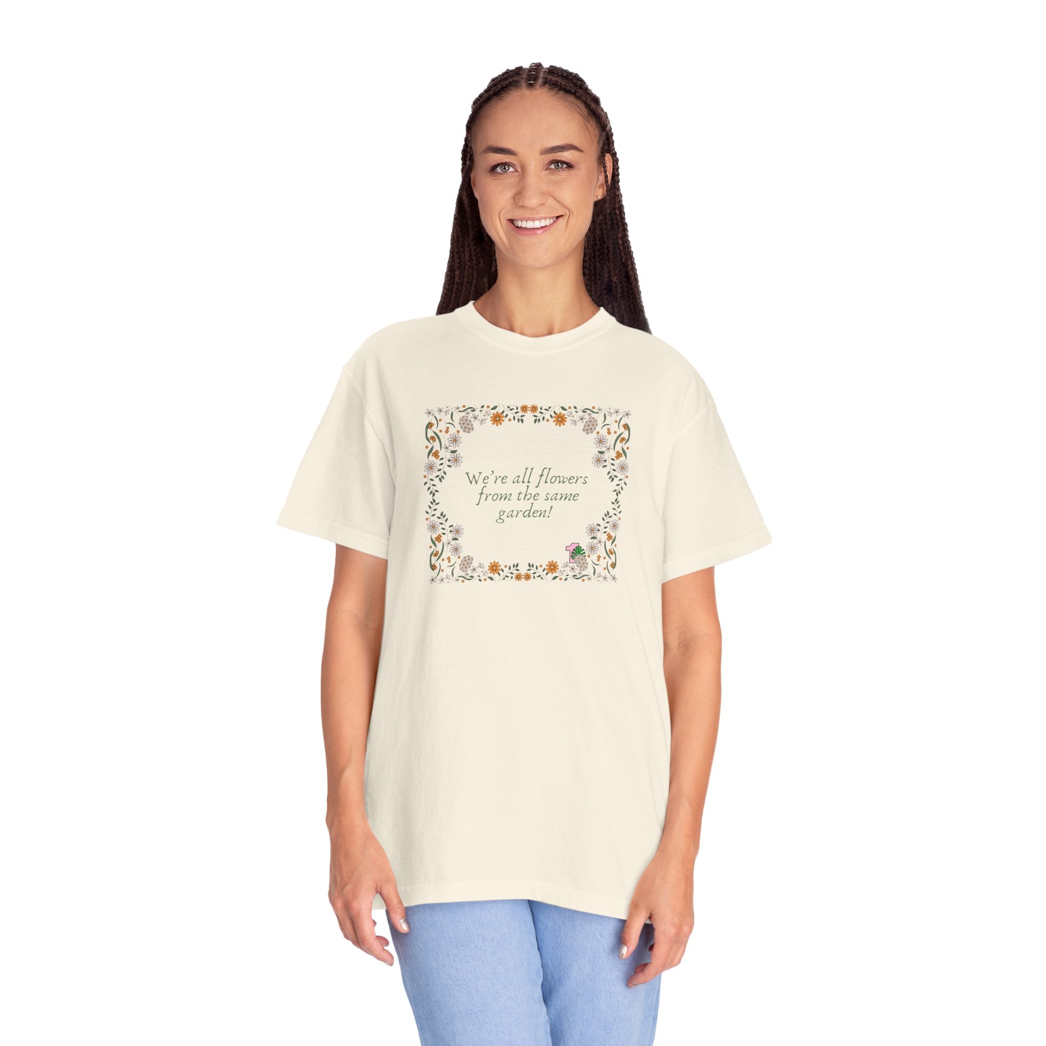 A person wearing a tee shirt with a sentence that says "we're all flowers from the same garden!" 