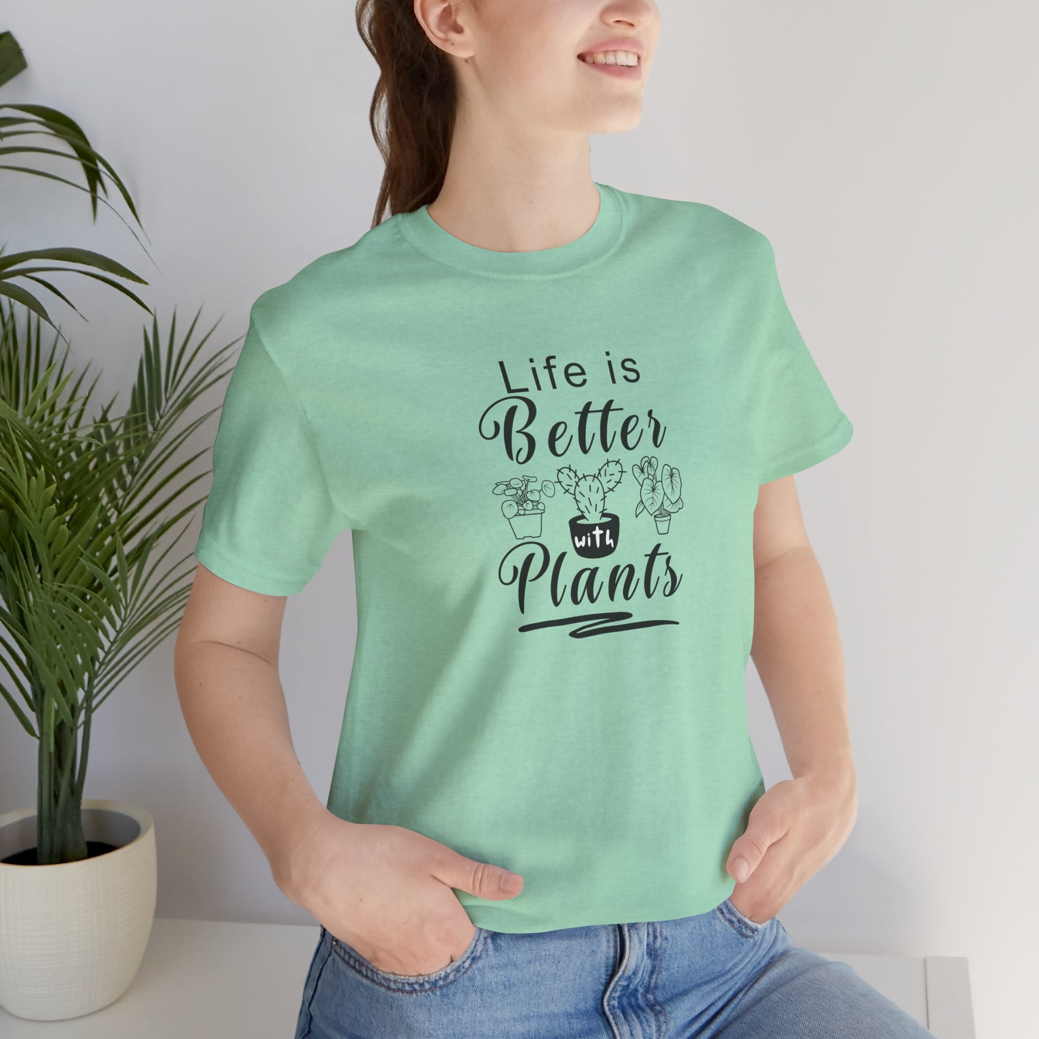 A picture of a person wearing a heather mint color tee shirt with "Life is Better with Plants" text printed on the front.  The text is printed in black color.