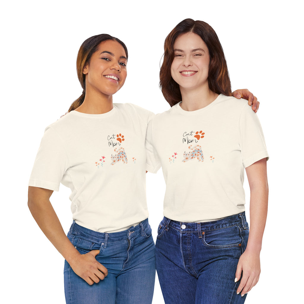 Tow ladies wearing a natural color t-shirt with the words "cat mom," a floral cat, and some flowers printed on the front of the shirt.