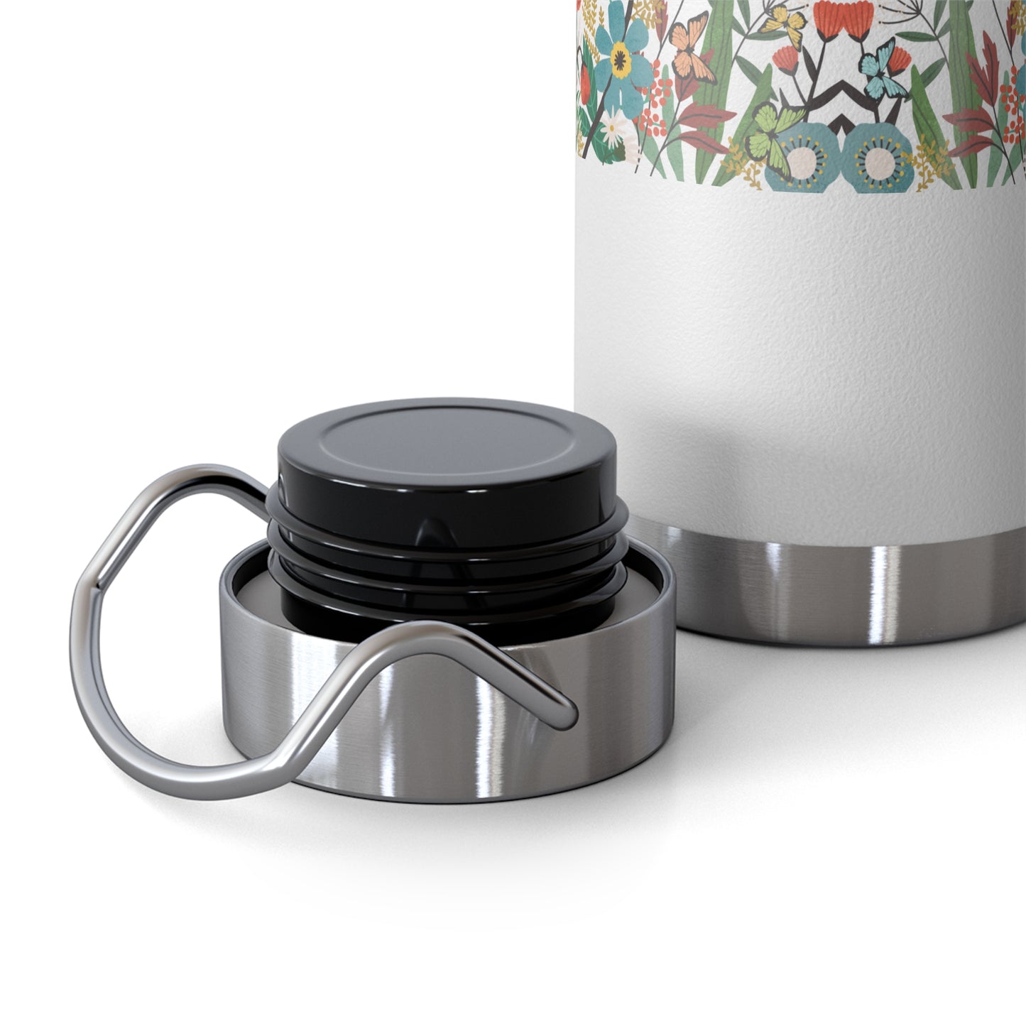 Silver insulated mug with black lid and floral-patterned sleeve on a white background