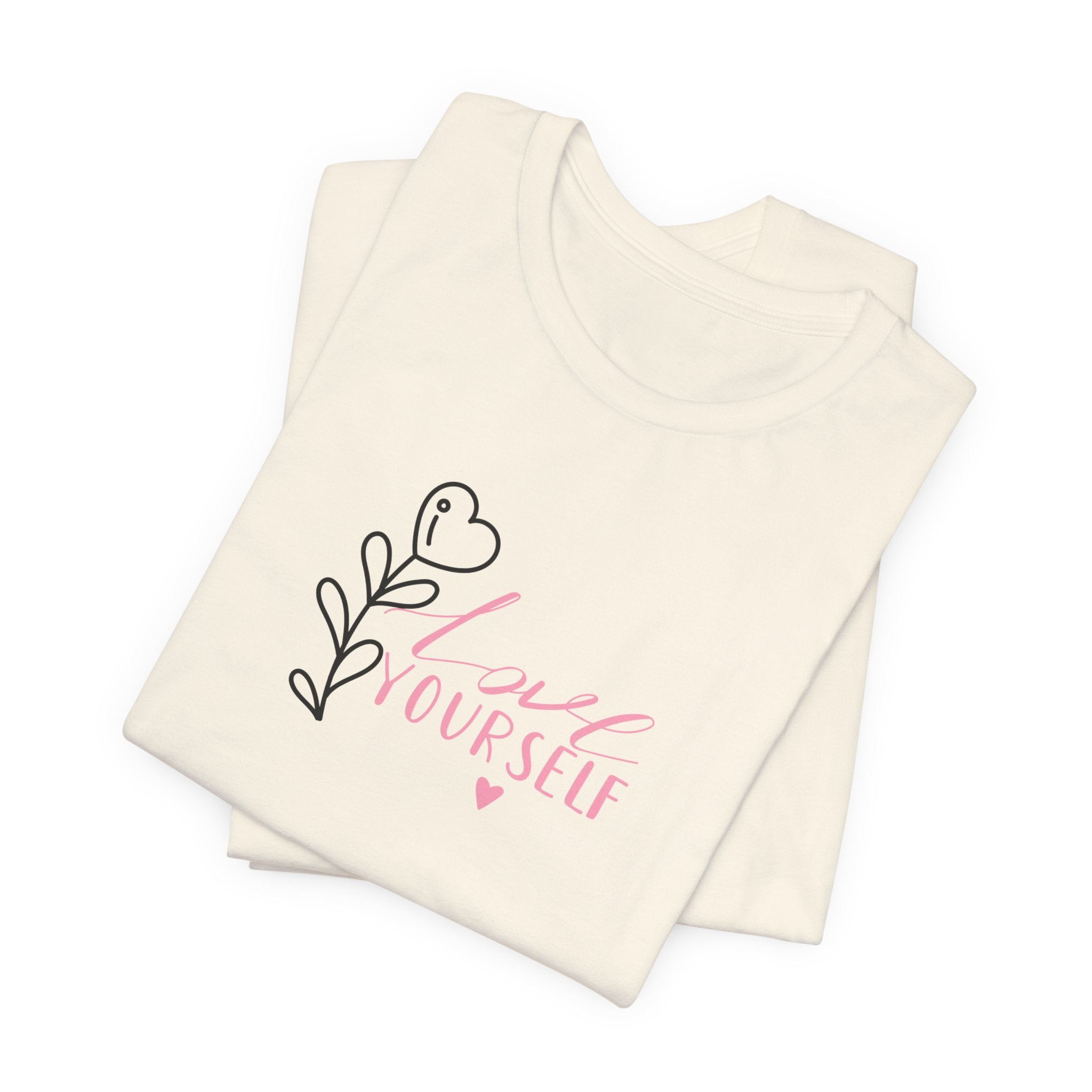 Picture of a natural color tshirt with pink text that says "love yourself".  