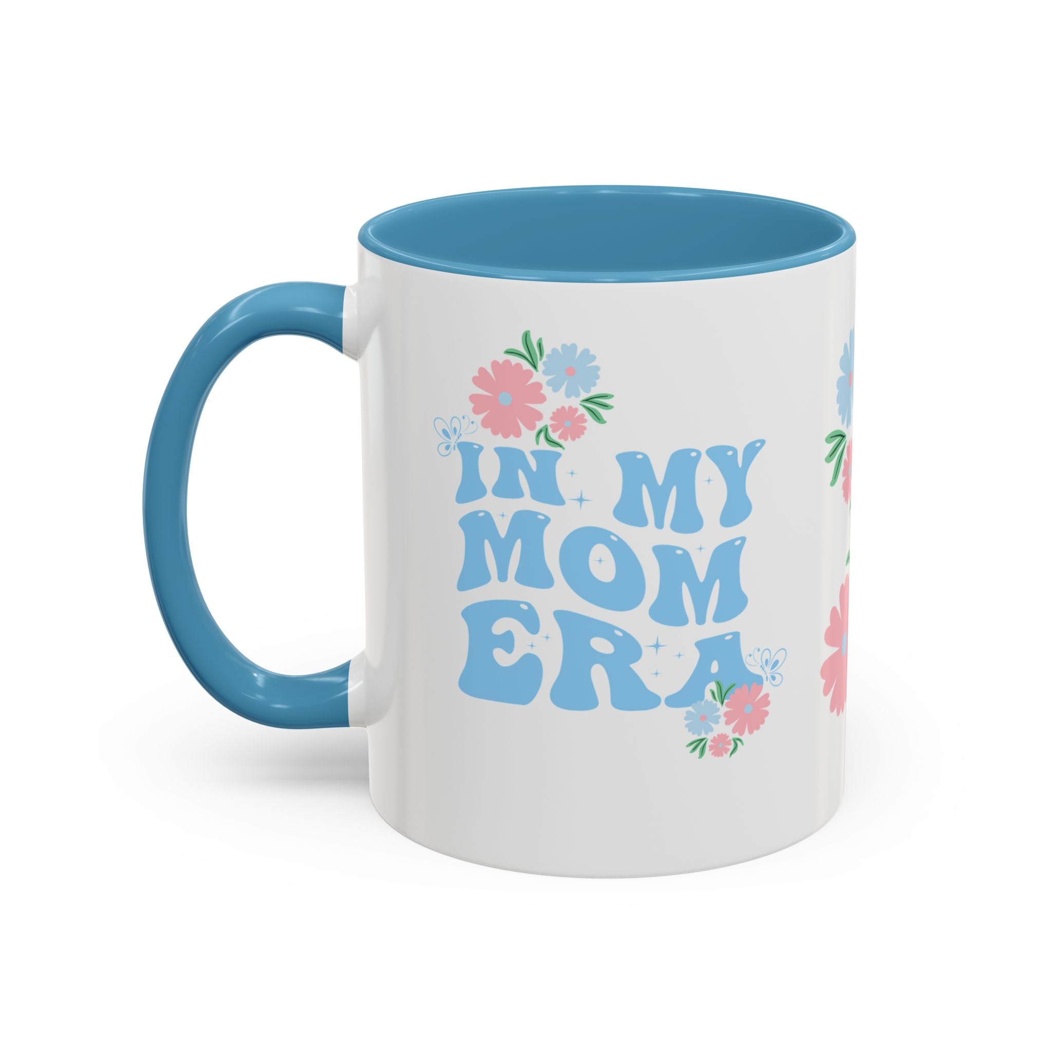 White mug with blue interior and handle, featuring floral designs and 'IN MY MOM ERA' text on a white background.