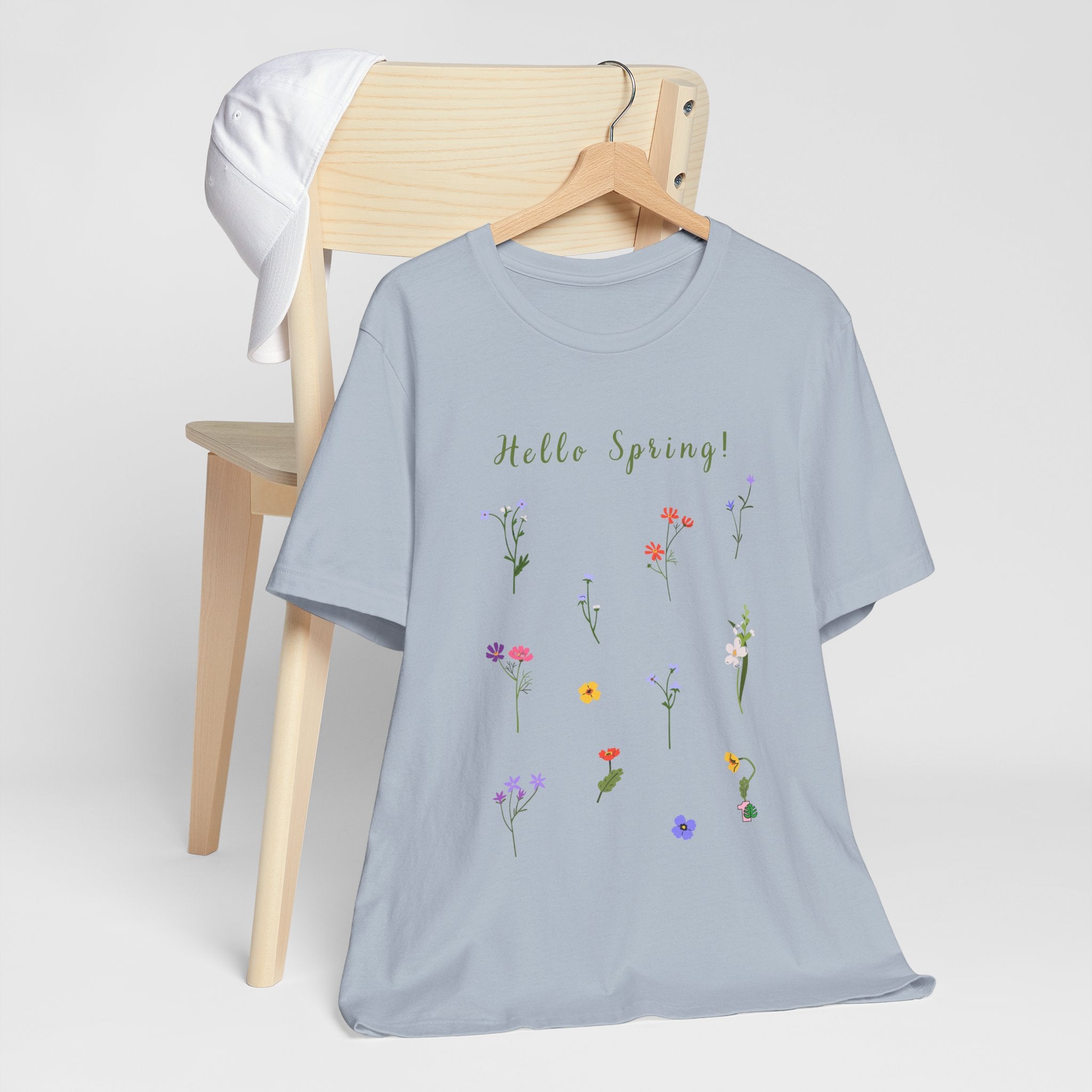 A short sleeve crew neck tee shirt with wild flowers print and text that reads "Hello Spring!" 