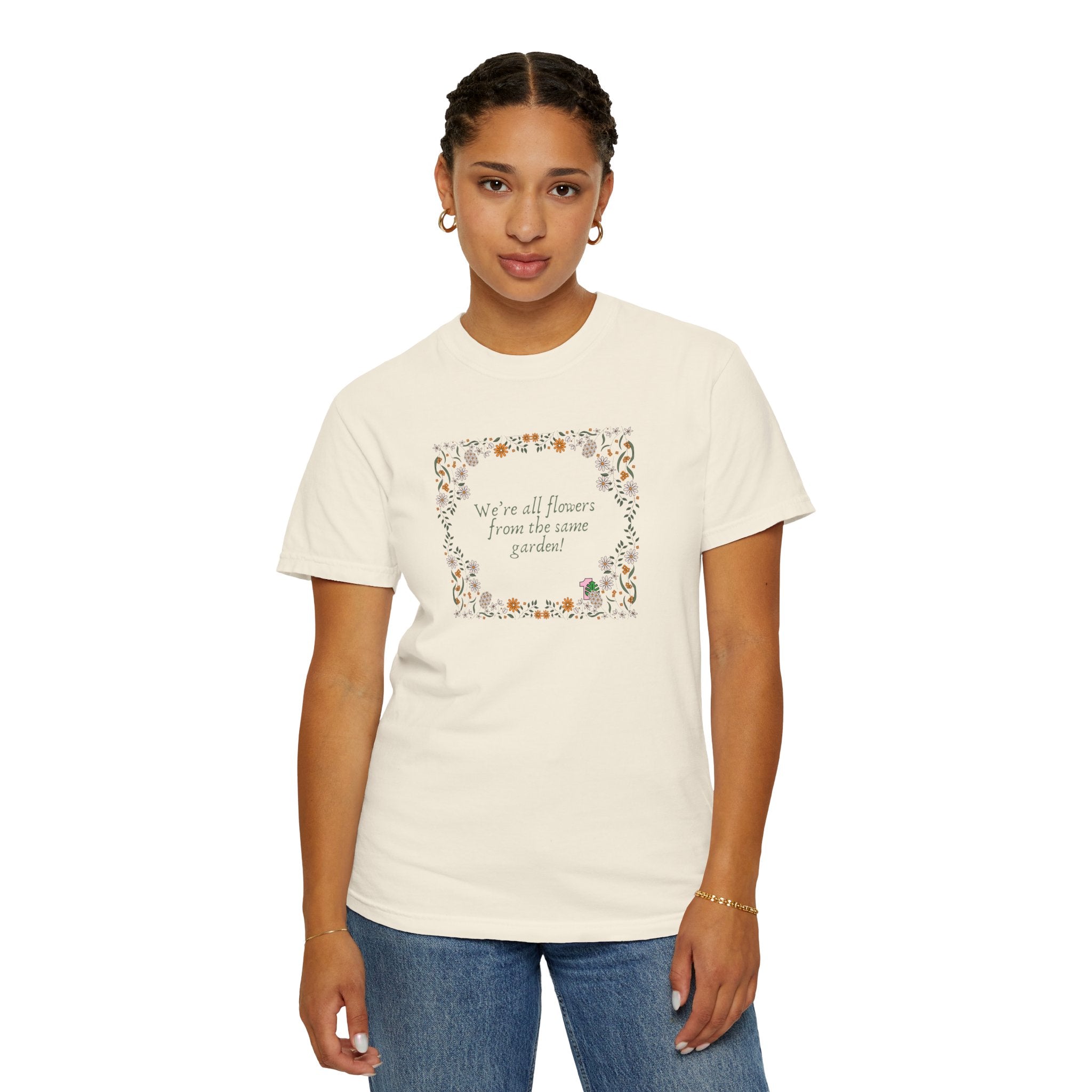 A person wearing a tee shirt with a sentence that says "we're all flowers from the same garden!" 