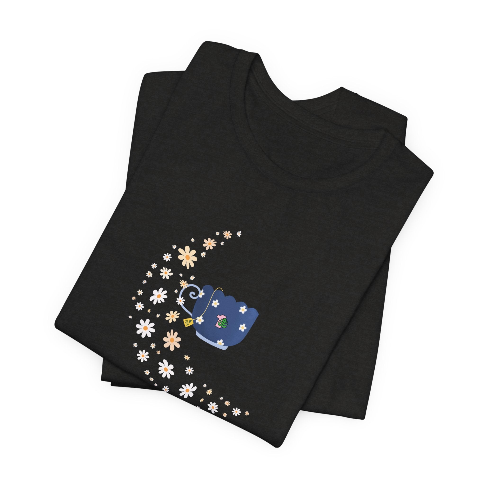 A whimsical floral moon and floral tea cup printed on a folded black colored shirt.