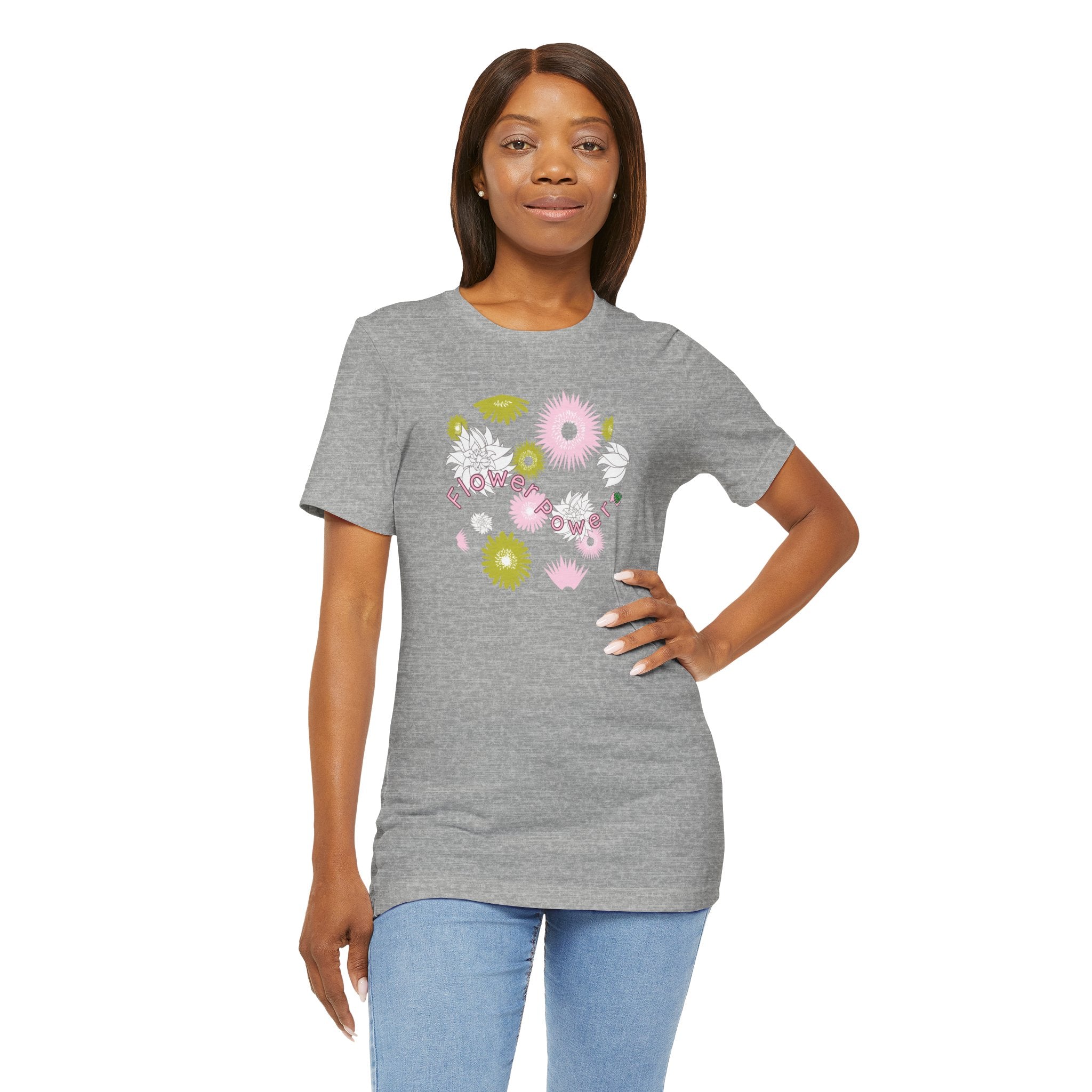 A person wearing an athletic heather color tee shirt with the words flower power in pink.  There are also pink, white, and green flowers printed on the shirt.