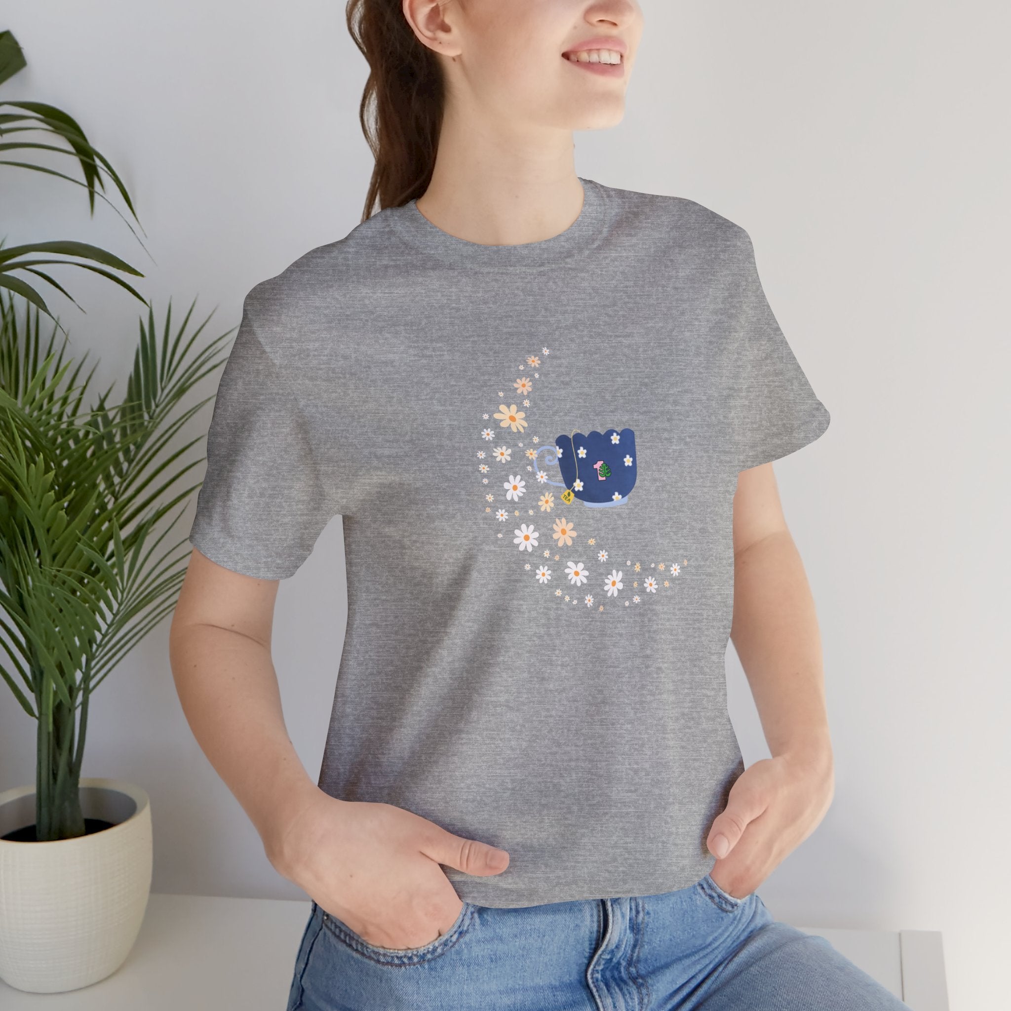 A student wearing a tshirt featuring a floral moon and a teacup design.  The shirt also has a crew neck and short sleeves.  