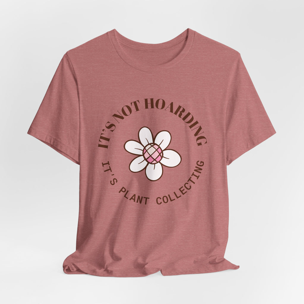 A heather mauve colored shirt with text that says "It's not hoarding" "It's plant collecting."  The shirt design also has a groovy flower. The shirt is an excellent gift for teen and adult female houseplant collectors. Perfect for birthdays and Christmas gifts. 