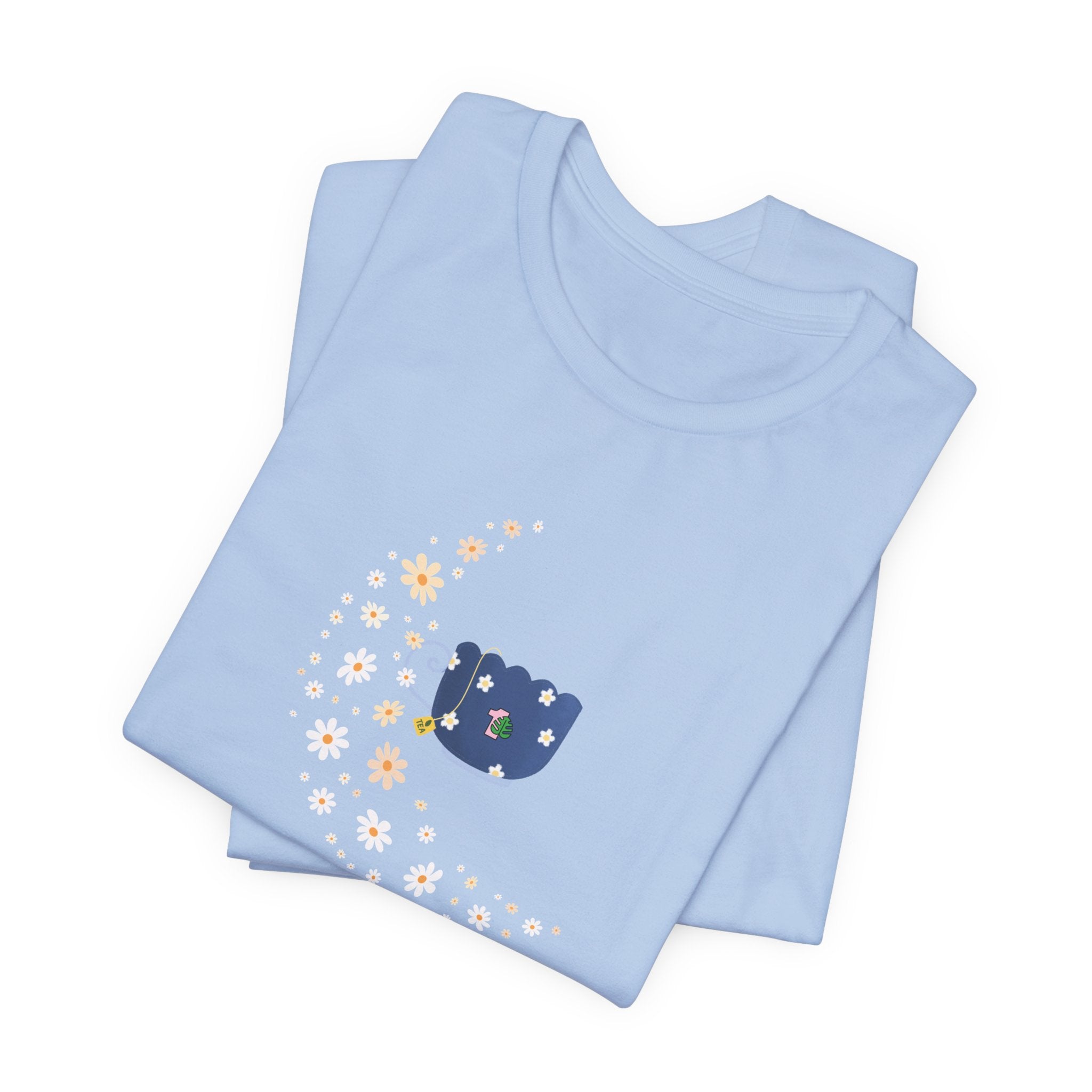 A whimsical floral moon and floral tea cup printed on a folded baby blue shirt.