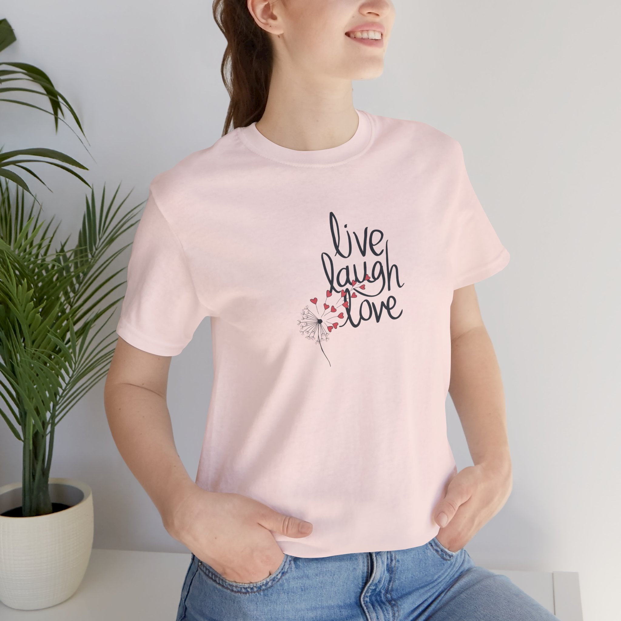 a shirt with a dandelion and text that says live, laugh, love.