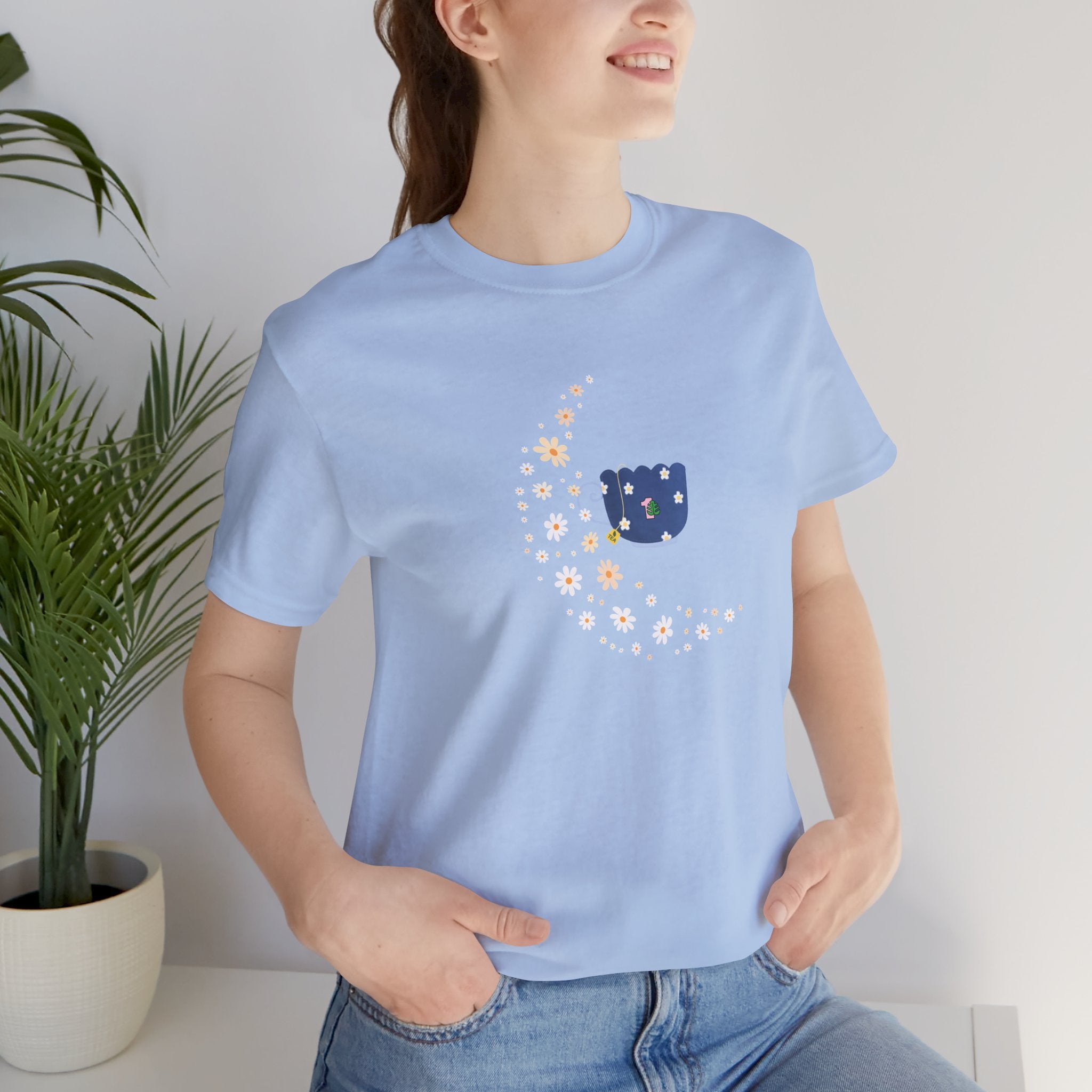 A person wearing a floral moon and floral tea cup design printed on a baby blue shirt.