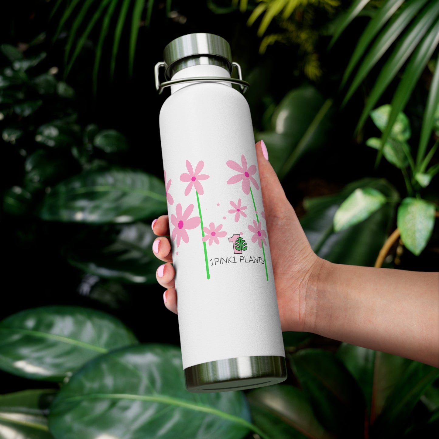 White water bottle with pink floral design held in front of green foliage