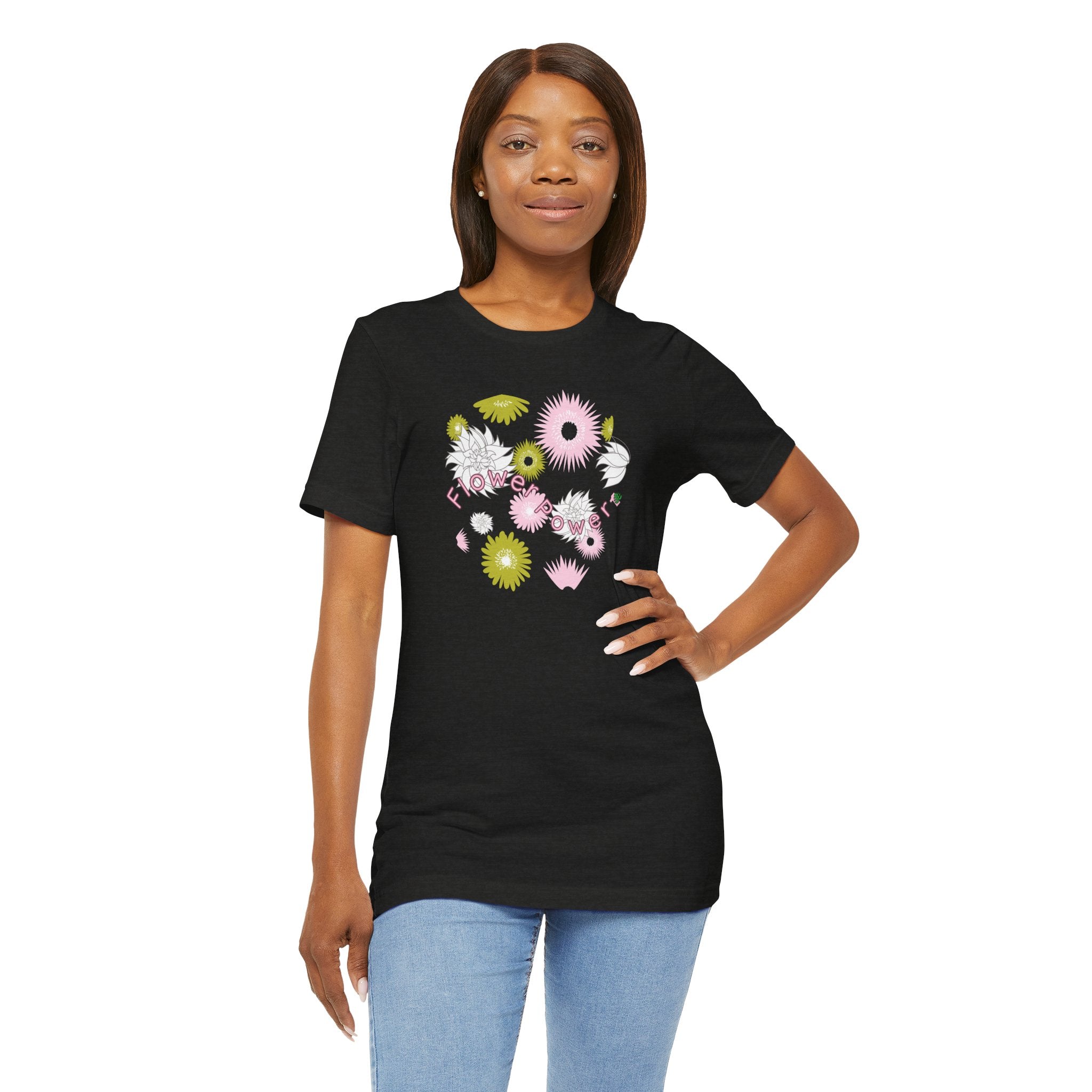 A person wearing a black color tee shirt with the words flower power in pink.  There are also pink, white, and green flowers printed on the shirt.