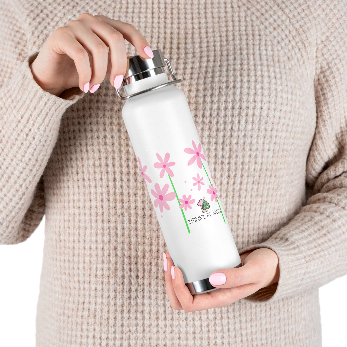Person holding a white water bottle with pink floral design and text.