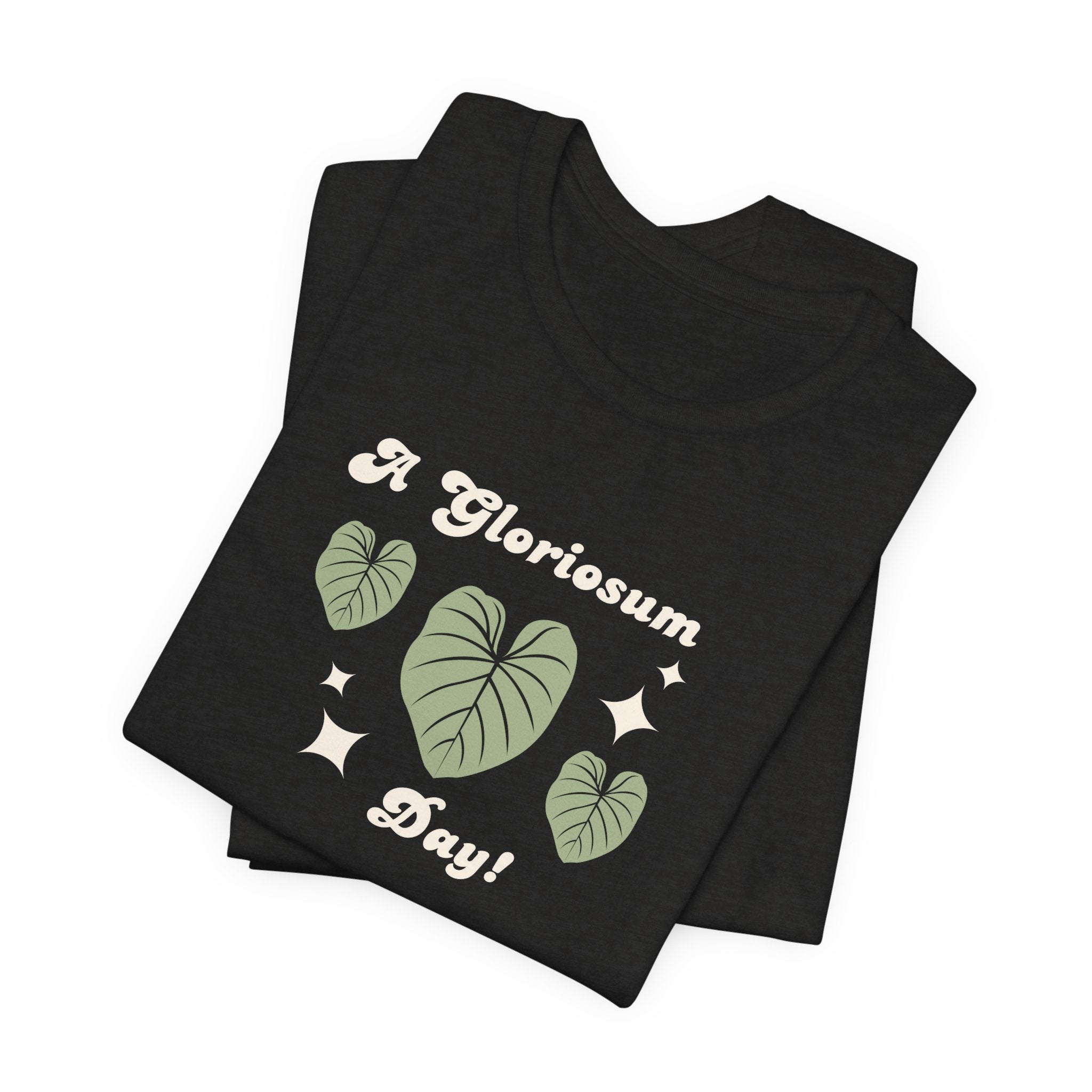 A plat t-shirt with a philodendron gloriosum plant design and text that says "A gloriosum Day!" An excellent gift for plant lovers, plant collectors, and plant enthusiasts. Great as a birthday gift. This folded t-shirt comes in a black Heather color.