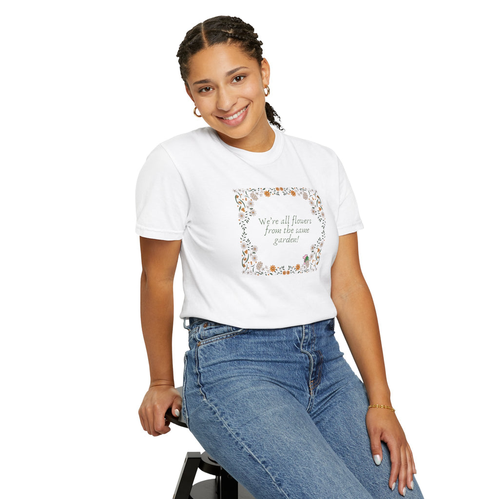 A young lady wearing a white shirt with text that says "We're all flowers from the same garden!"  The text is surrounded by a floral frame. 