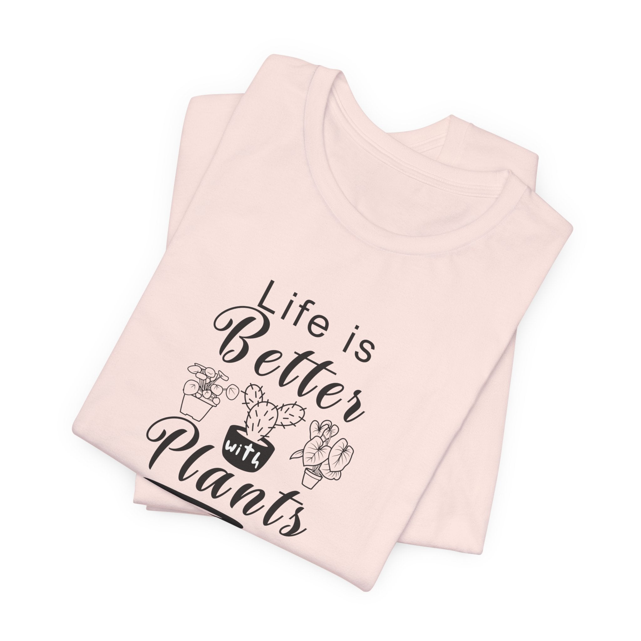 a folded pink shirt with "Life is Better with Plants" text in black  
