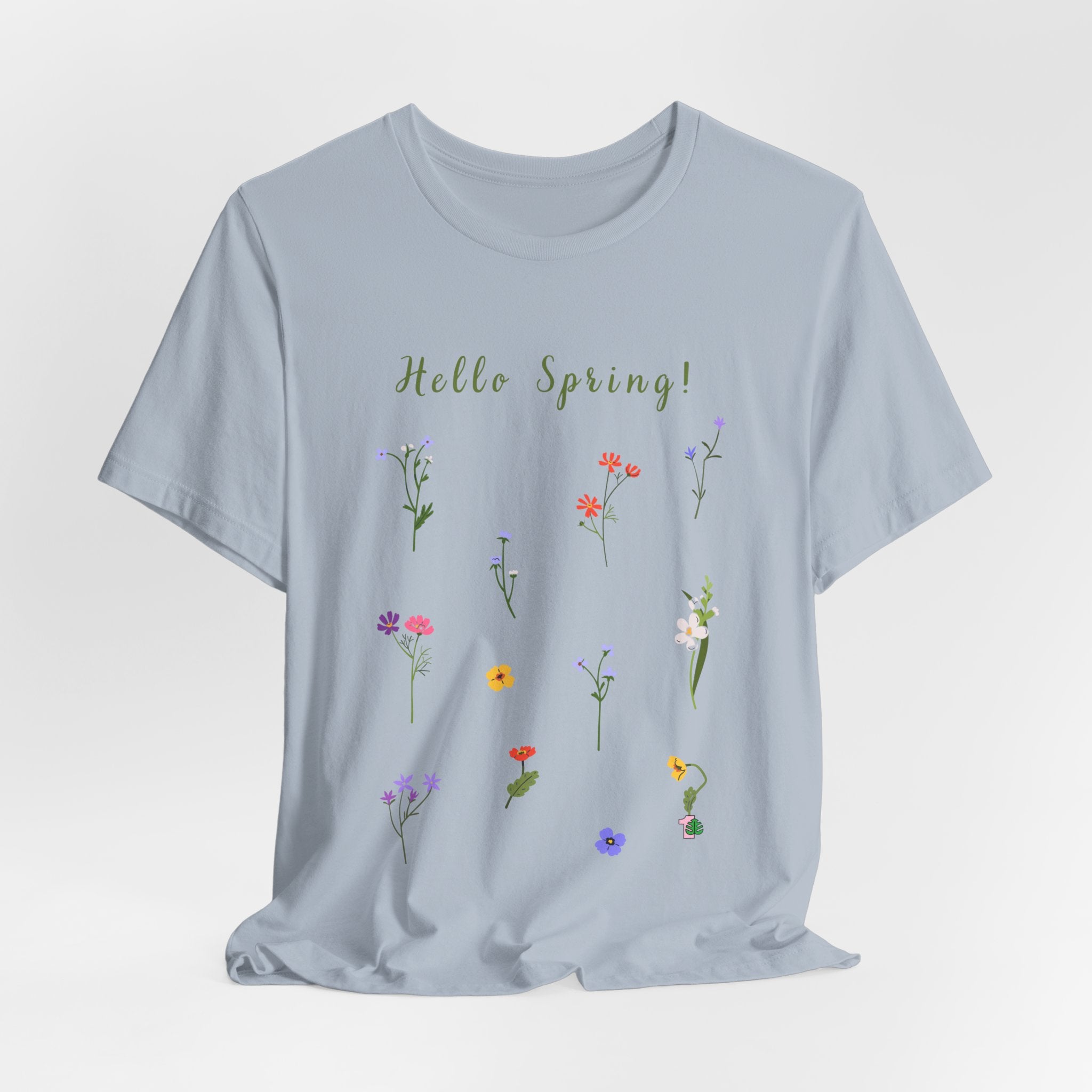 A crew neck t-shirt with wild flowers print and text that reads "Hello Spring!" The shirt is made with cotton and is lightweight. Perfect for watering houseplants, gardening, or relaxing at home with house plants.