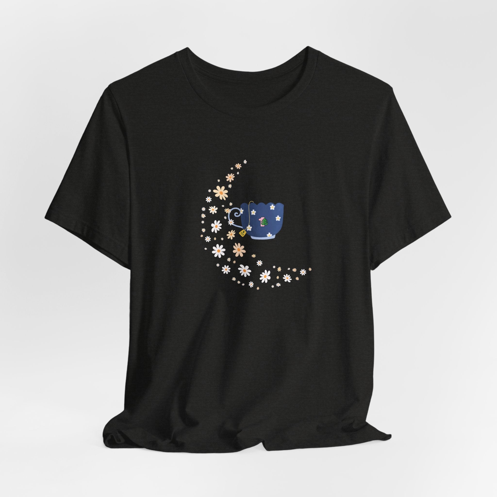 A whimsical floral moon and floral tea cup printed on a folded black colored shirt.