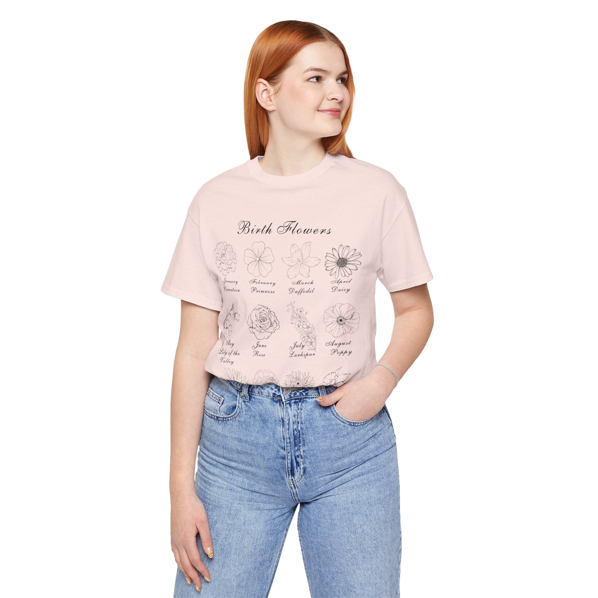 A young lady wearing a soft pink colored shirt with a printed design of birth flowers.  Each month of the year is printed with a corresponding flower for that particular month.  The t-shirt has a crew neck and short sleeves.  It is also lightweight so it's perfect for layering.  It also makes an excellent birthday, Mother's Day, Valentine's Day or Christmas gift. 