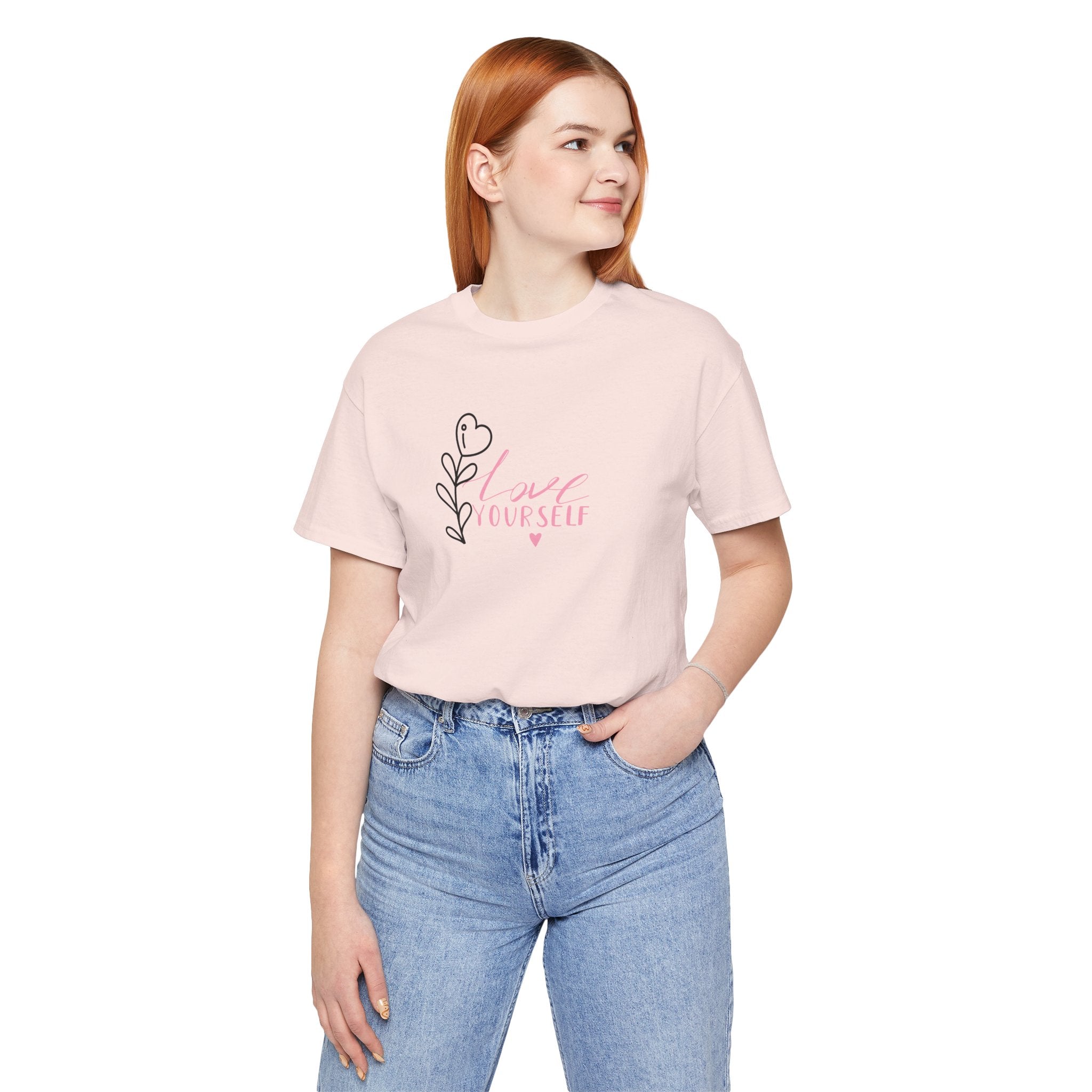 picture of a person wearing a soft pink shirt with the text love yourself.  This shirt encourages confidence in  the person that wears it and reads it. 