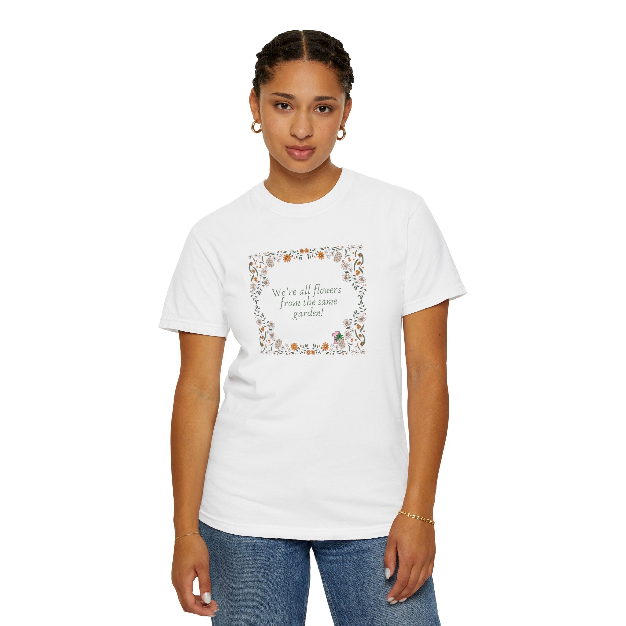 A young lady wearing a white shirt with text that says "We're all flowers from the same garden!"  The text is surrounded by a floral frame. 